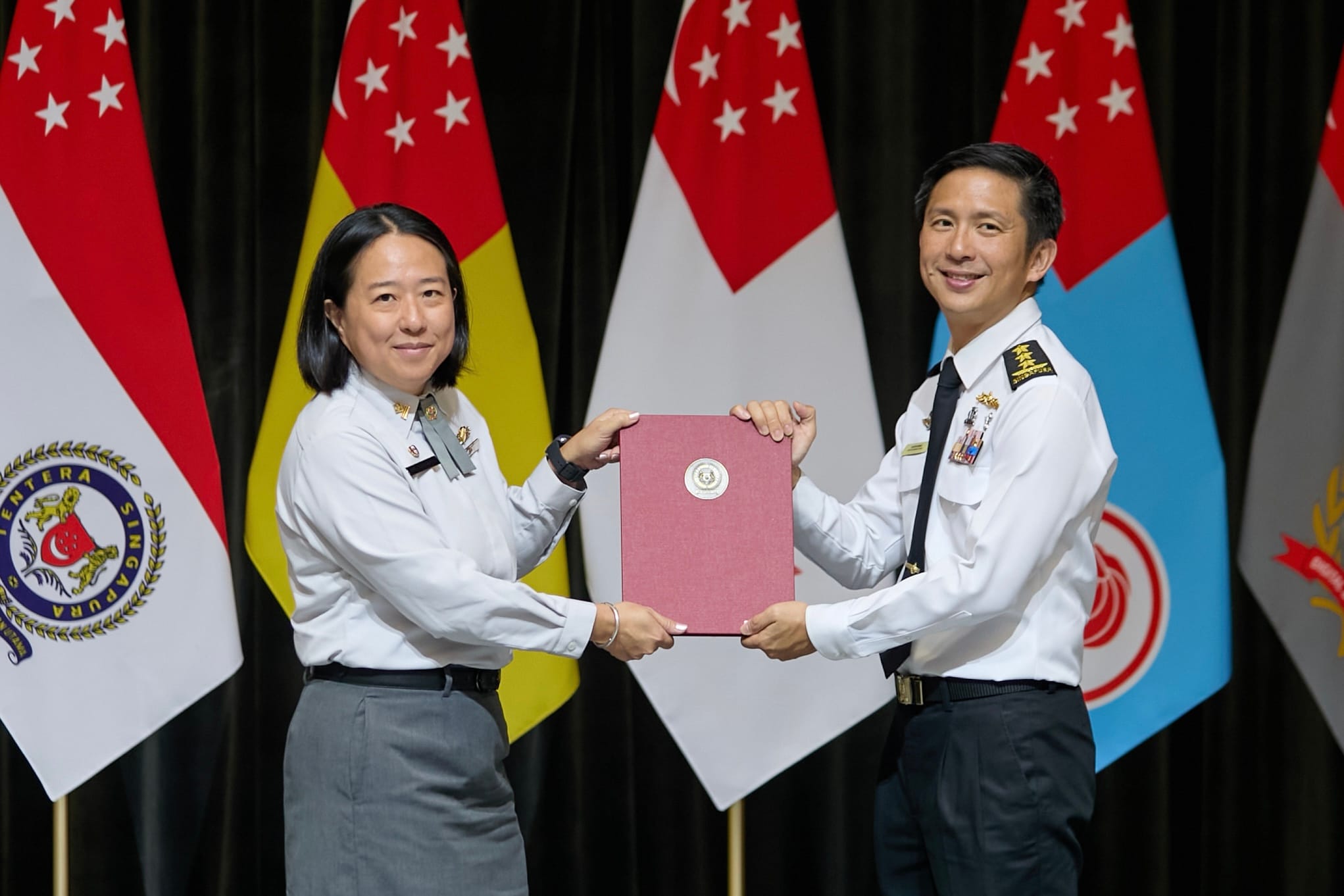 VADM Beng presenting the promotion certificate to ME5 Ong Li Xuan Lilian, who is promoting to the rank of ME6.