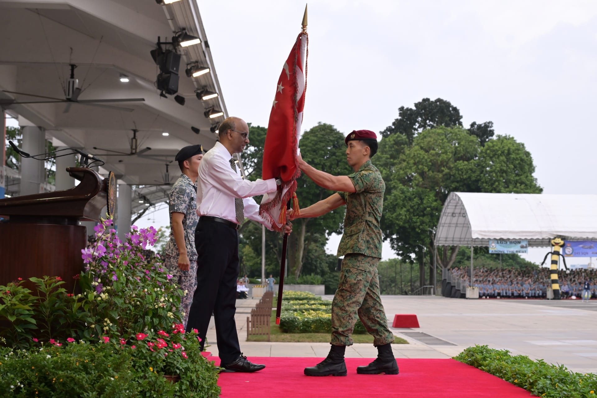 Commanding Officer of the 1st Commando Battalion Major (MAJ) Marcus Cheong receiving the State Colours from President Tharman.