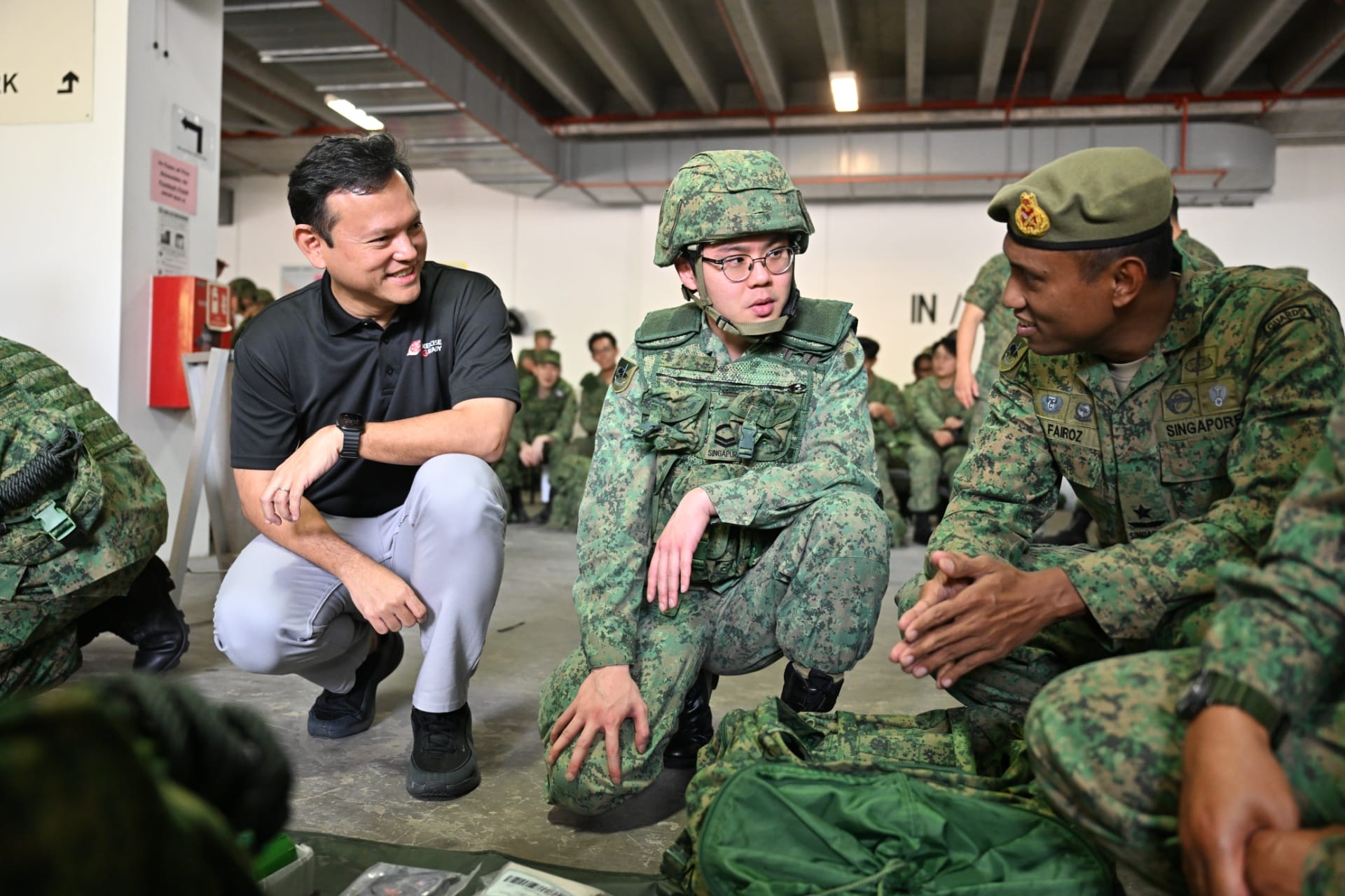 Senior Minister of State for Defence, Mr Zaqy Mohamad (left) engaging NSmen at the Personal Equipment Inspection station.