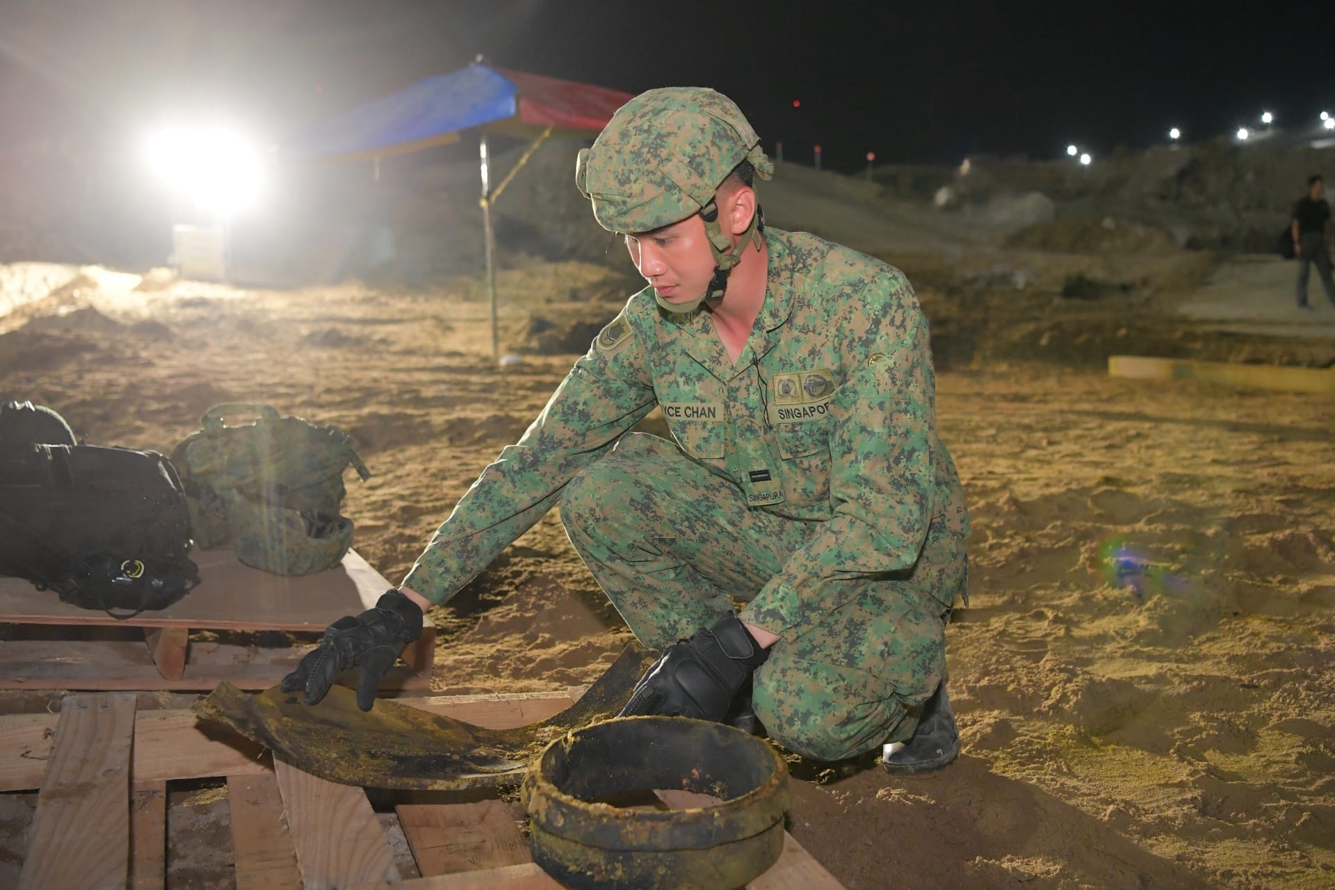 Singapore Army personnel inspecting recovered fragments to ensure they are safe following UXO disposal.