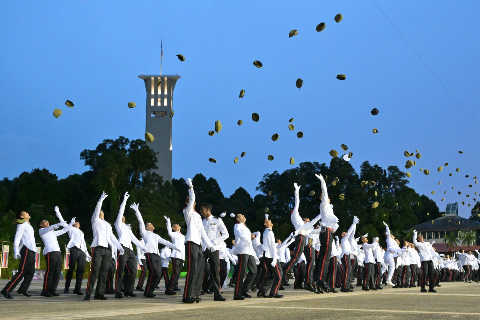 The newly commissioned officers tossing their headdresses to mark the completion of their 38-week course.