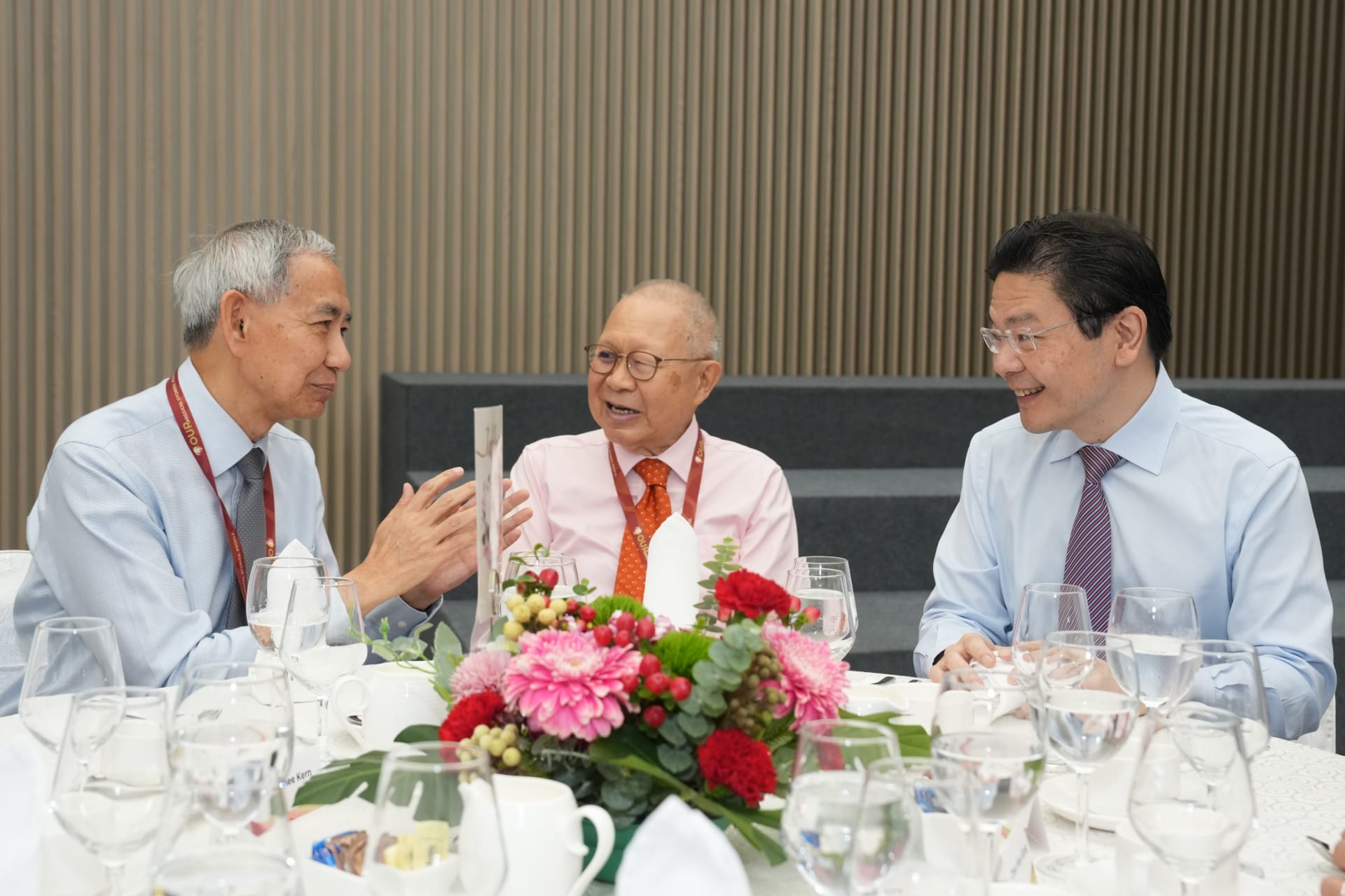 Prime Minister Wong interacting with Security and Intelligence Division alumni (left) Mr Choi Shing Kwok and (right) Mr Eddie Teo.