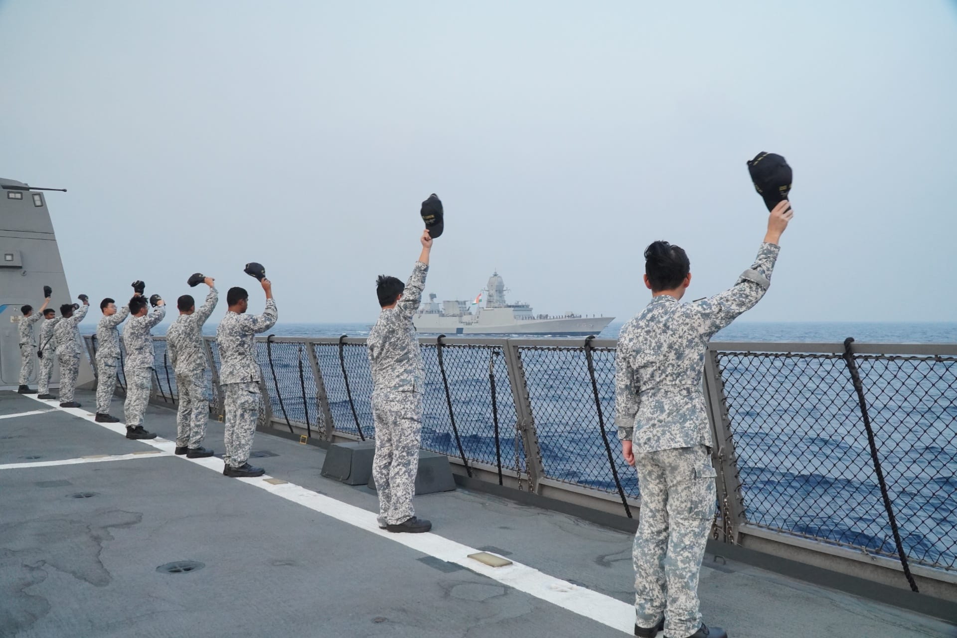 RSN personnel aboard RSS Supreme waving off INS Nilgiri during the farewell sail-past.