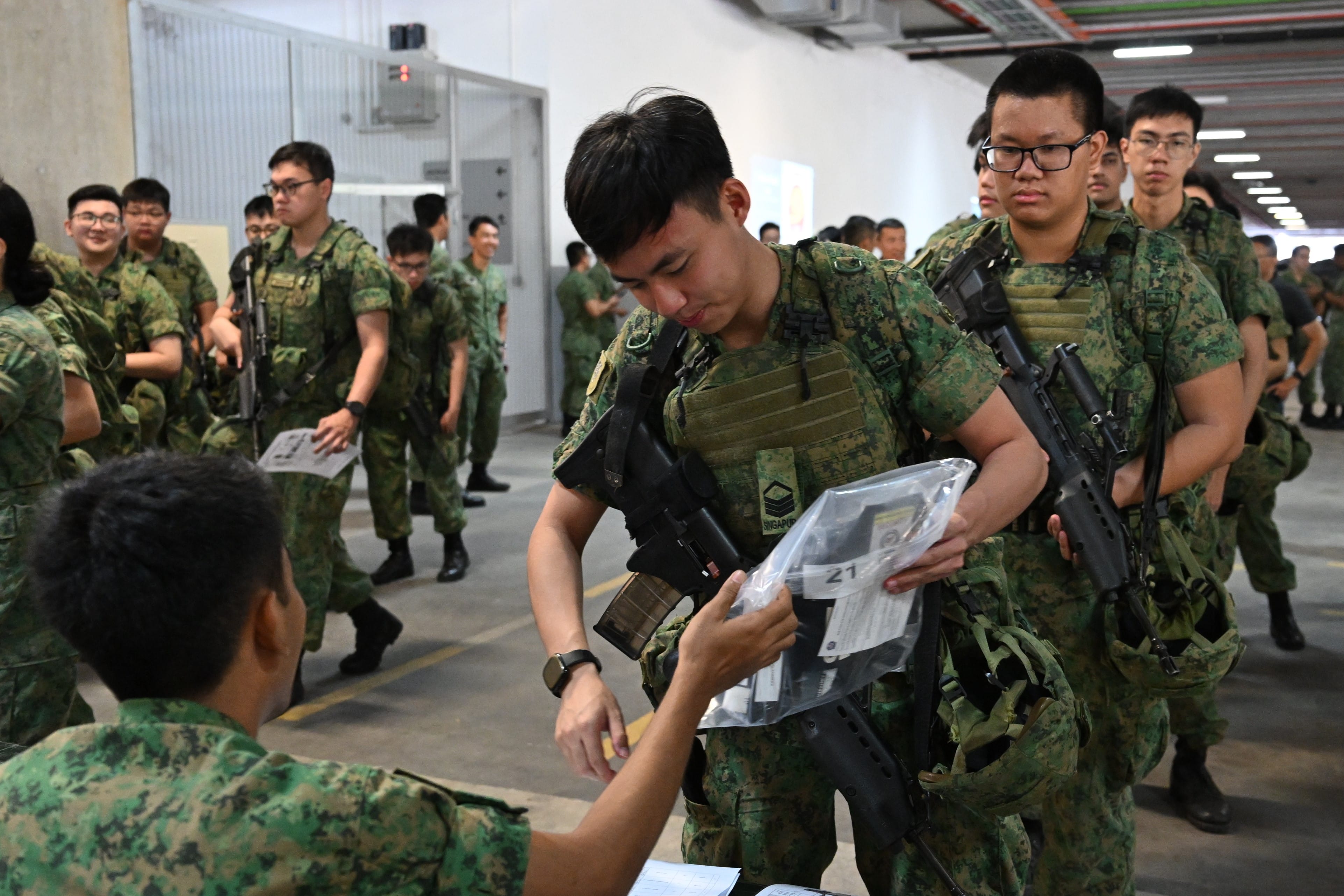 Activated soldiers from the Singapore Army equipping themselves with the mission essentials at Selarang Camp this morning.