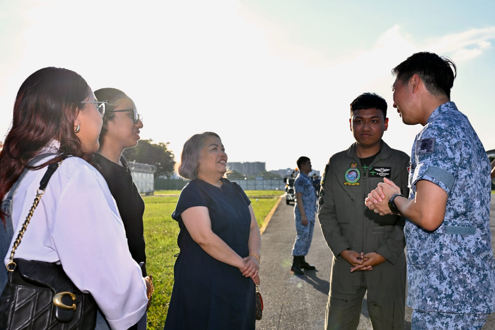 Chief of Air Force Major-General MG Kelvin Fan interacting with a mission crew and his family at the homecoming ceremony