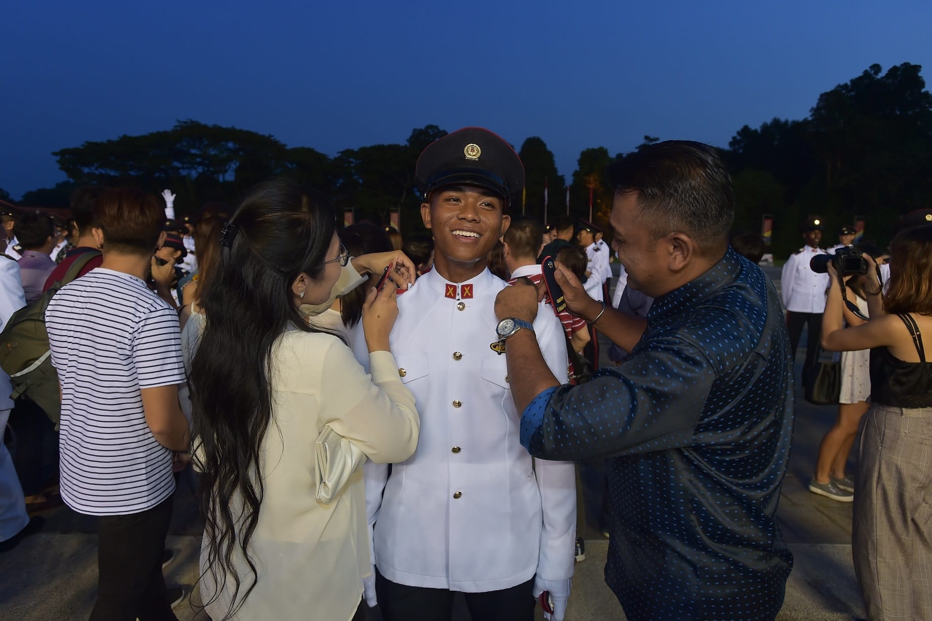 OCT Alfian Noorhaqim bin Rahmat's family affixing the Second Lieutenant rank epaulettes on him.
