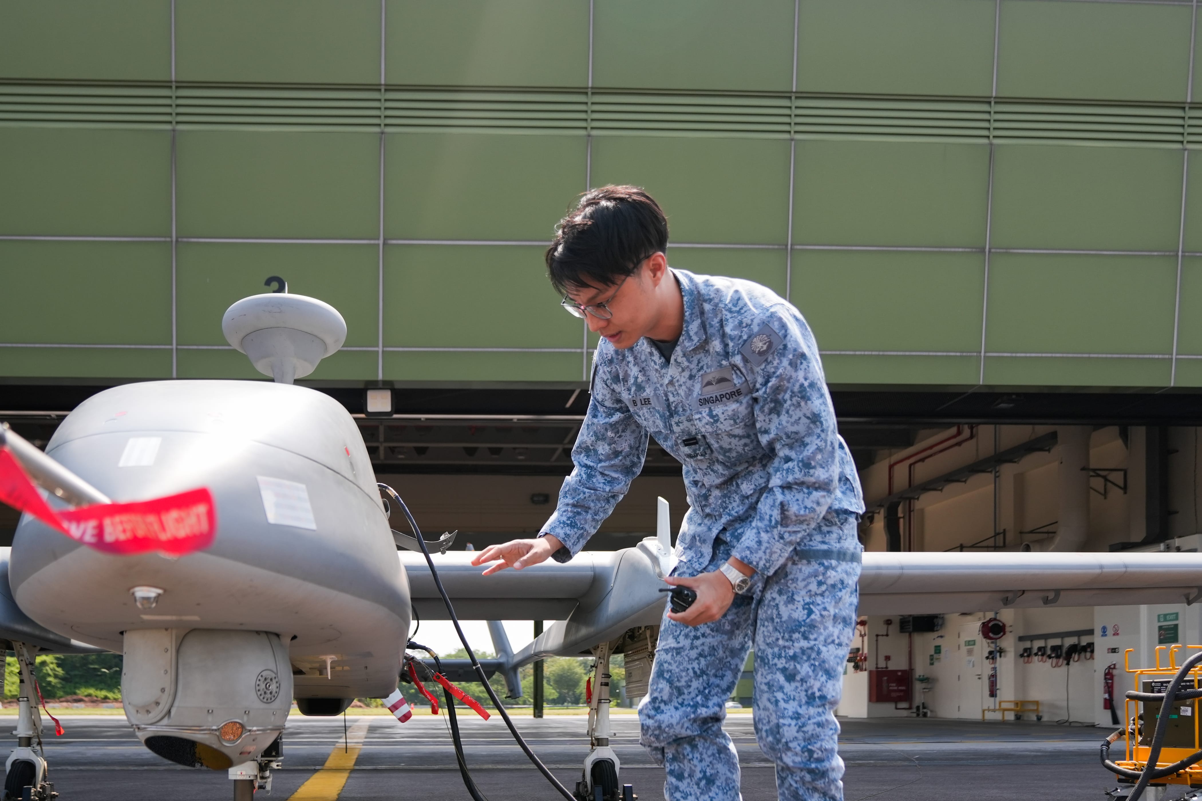 A UAV Pilot conducting walk-around checks on the Heron 1 UAV to ensure that the UAV is ready when called upon.
