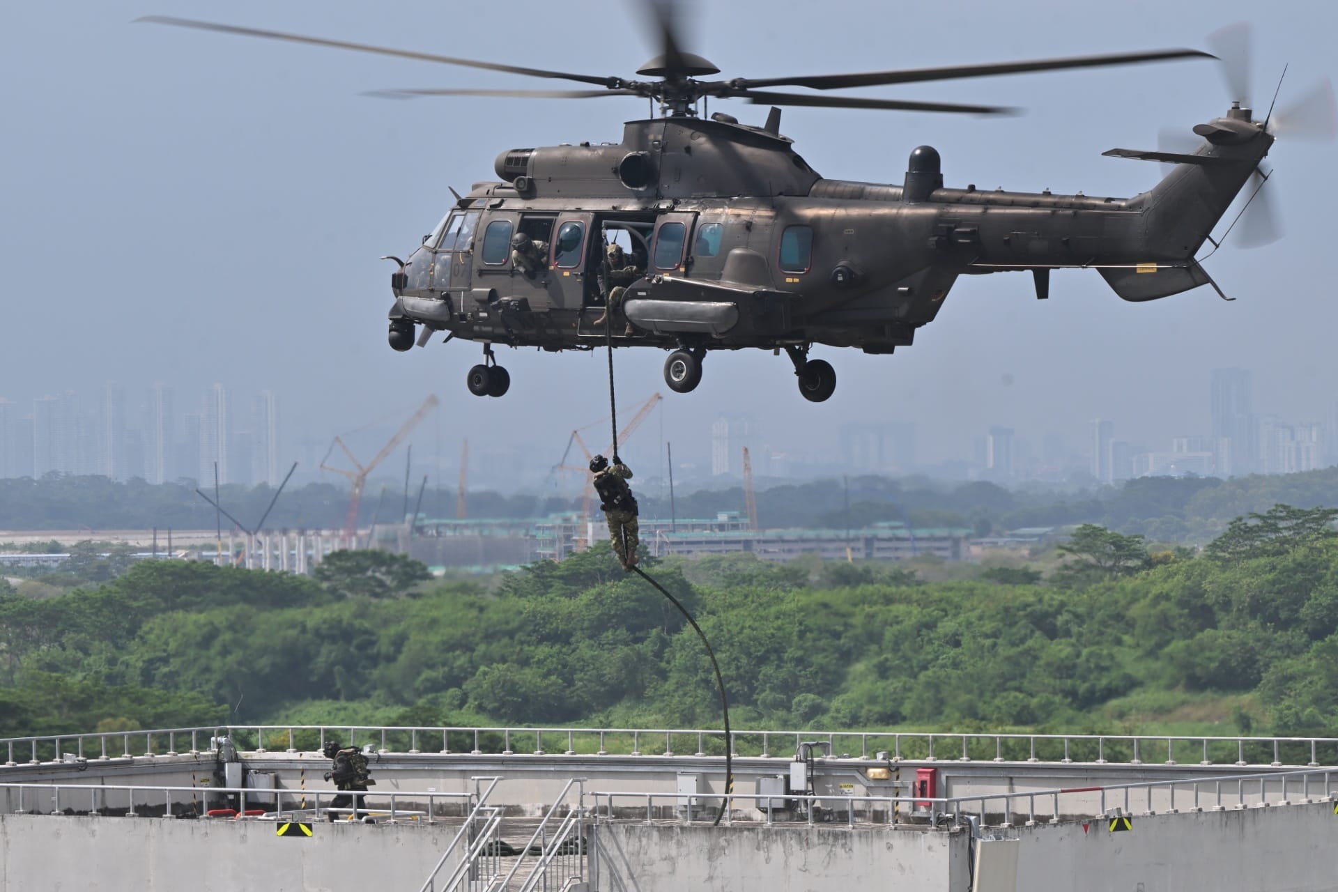 A soldier from TNI KOPASSUS executing a heli fast-roping drill as part of Exercise Chandrapura 2026.