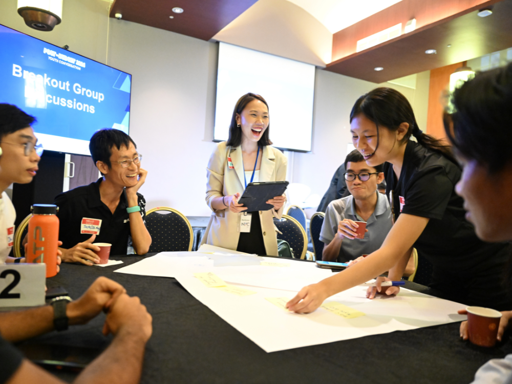 A group of participants smiling and having a discussion.