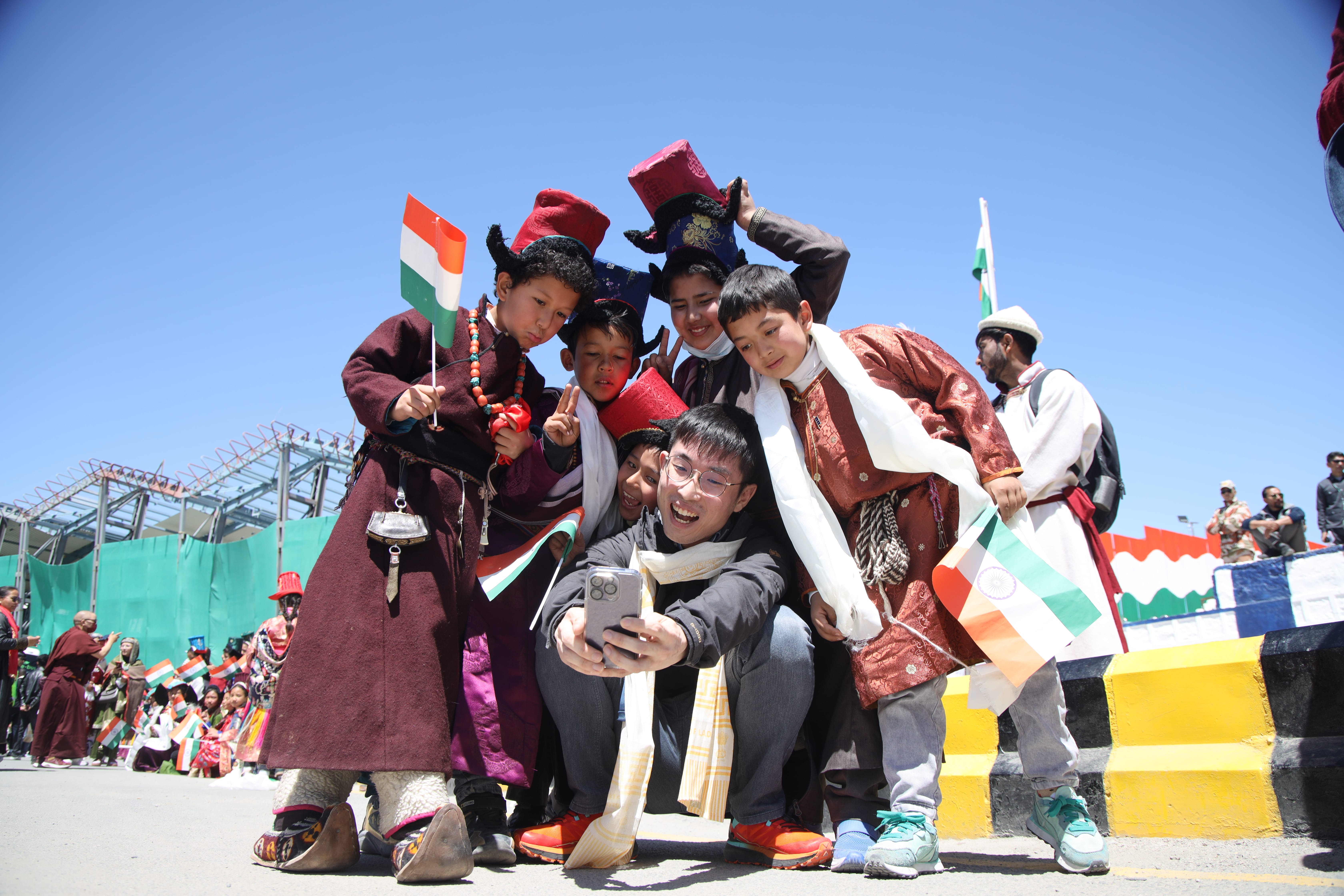 A participant taking a group selfie with kids in their traditional costumes.