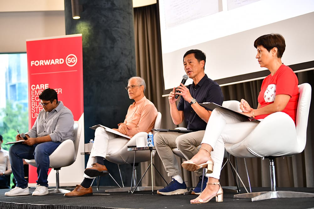 Panel discussion with four people on stage, "Forward SG" banner visible.