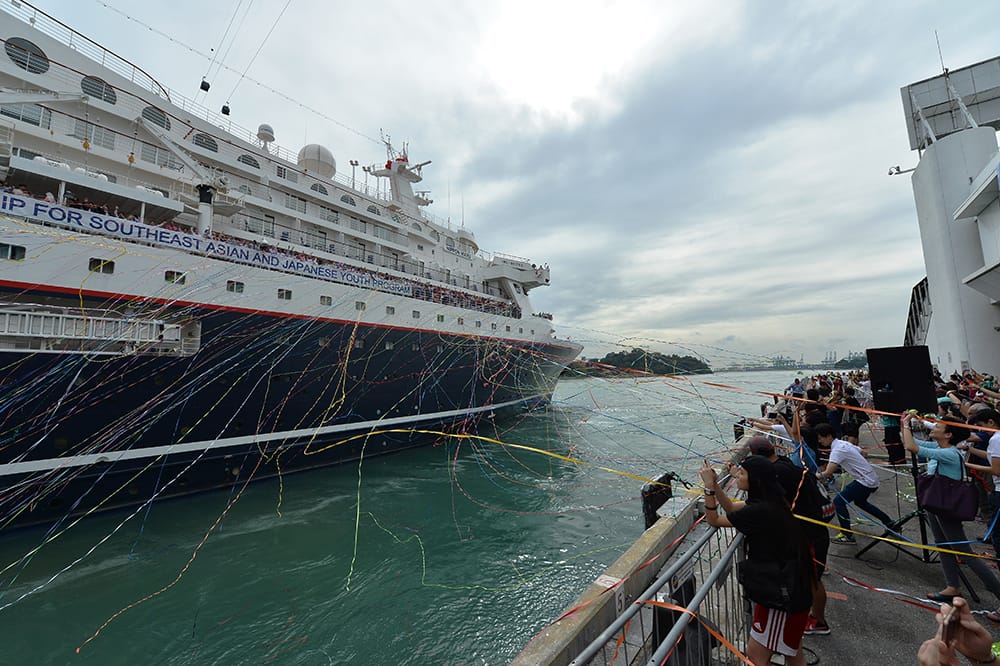 People wave streamers as the Nippon Maru ship departs