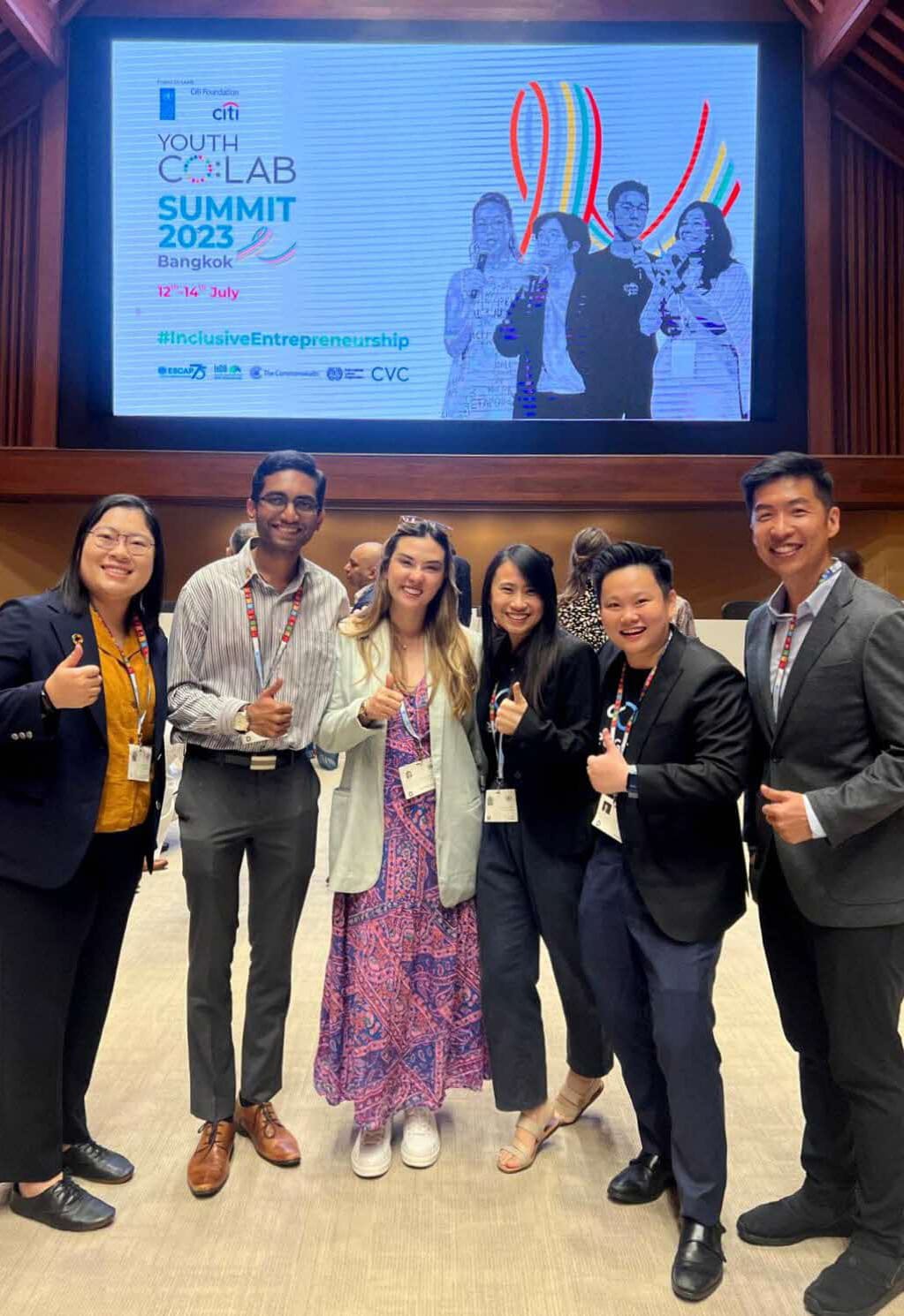 Group poses, giving thumbs up, at Youth Co:Lab Summit 2023 Bangkok event.