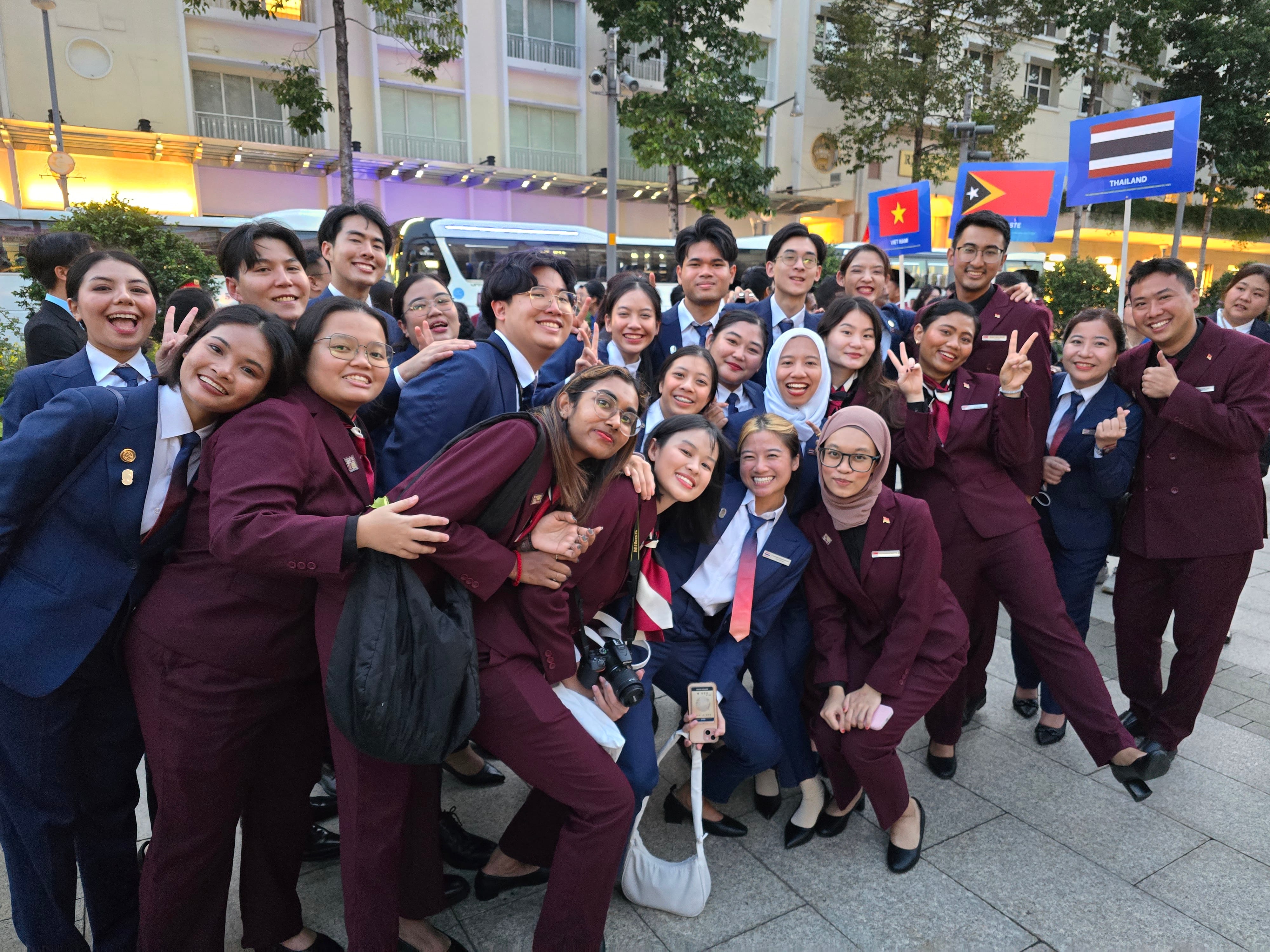 A group of people in suits squeezing together for an informal and fun group photo.