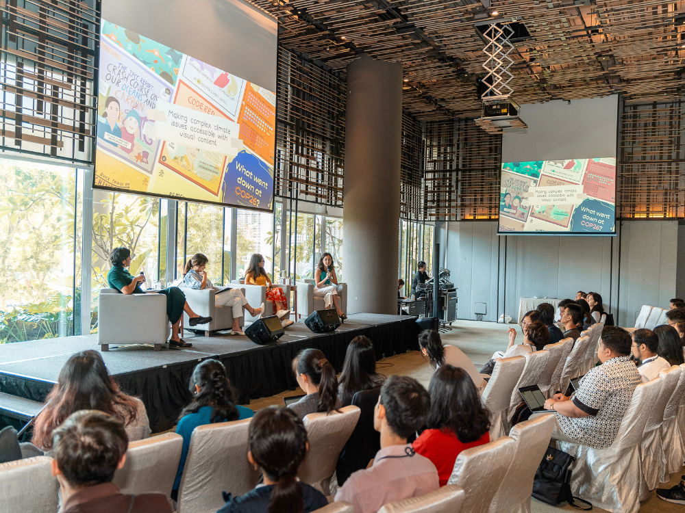 Panel discussion with four women on stage before an audience