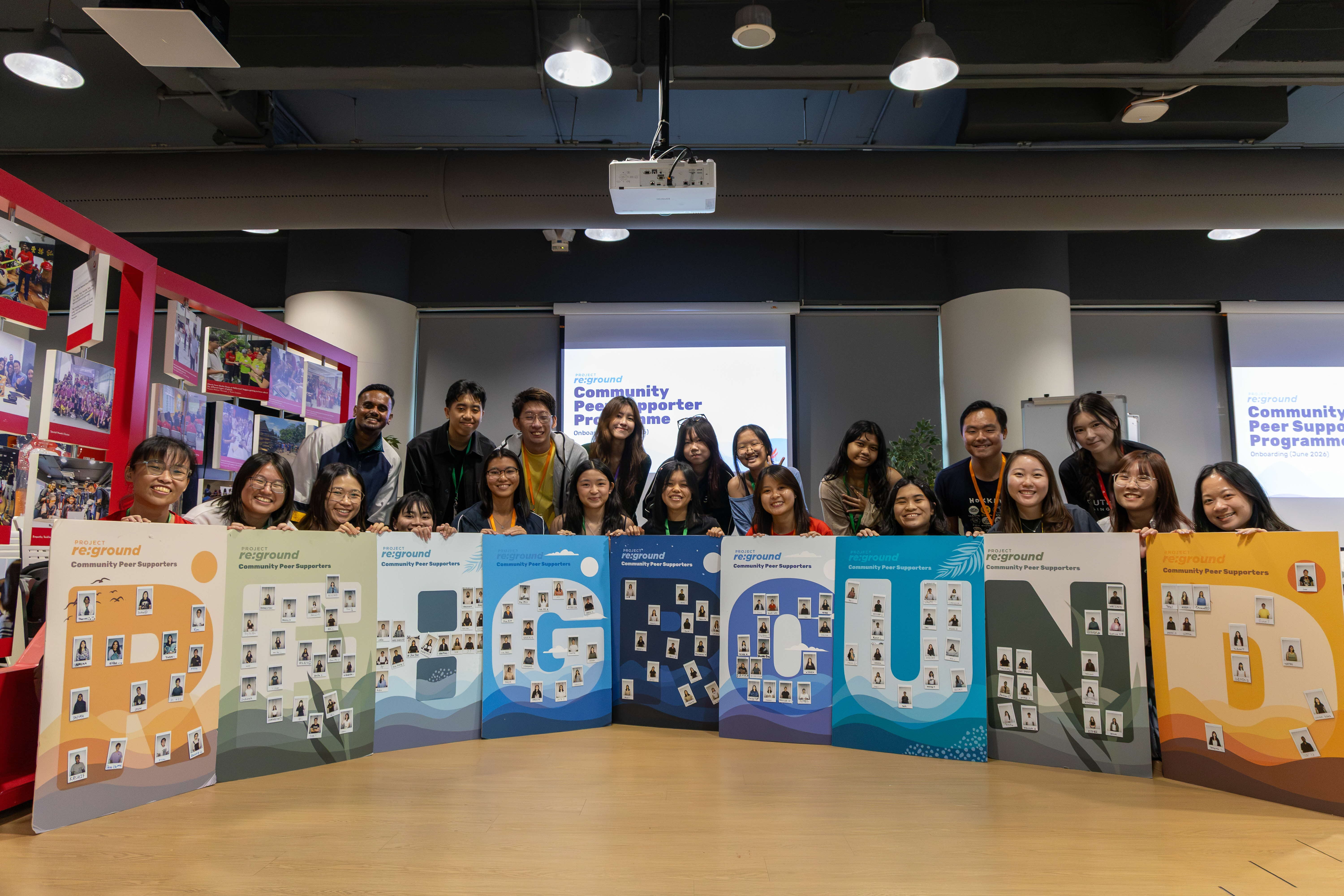 A group of Youth Corps volunteers posing together with Re:ground sign