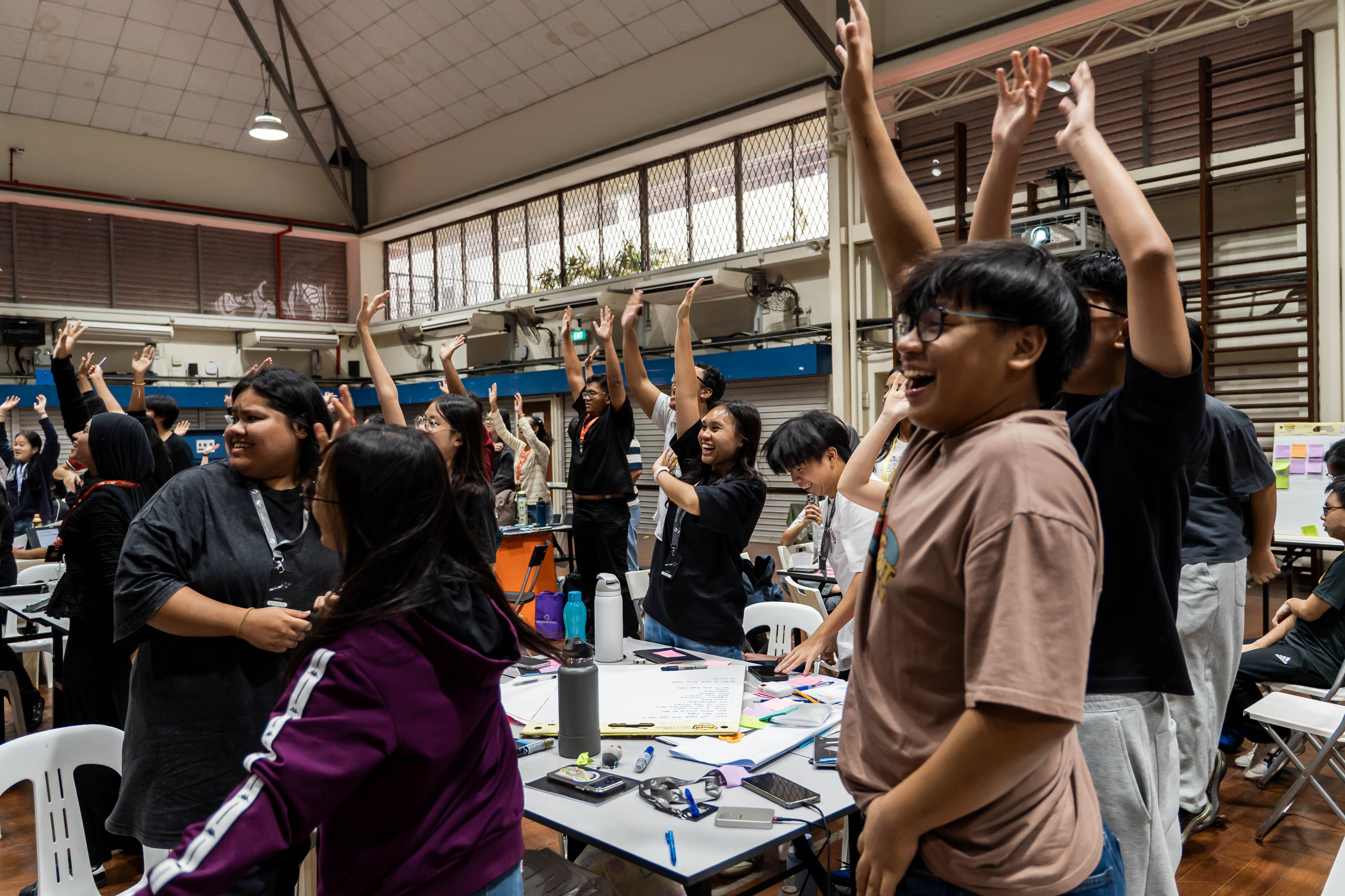 Youths raising their hands excitedly.