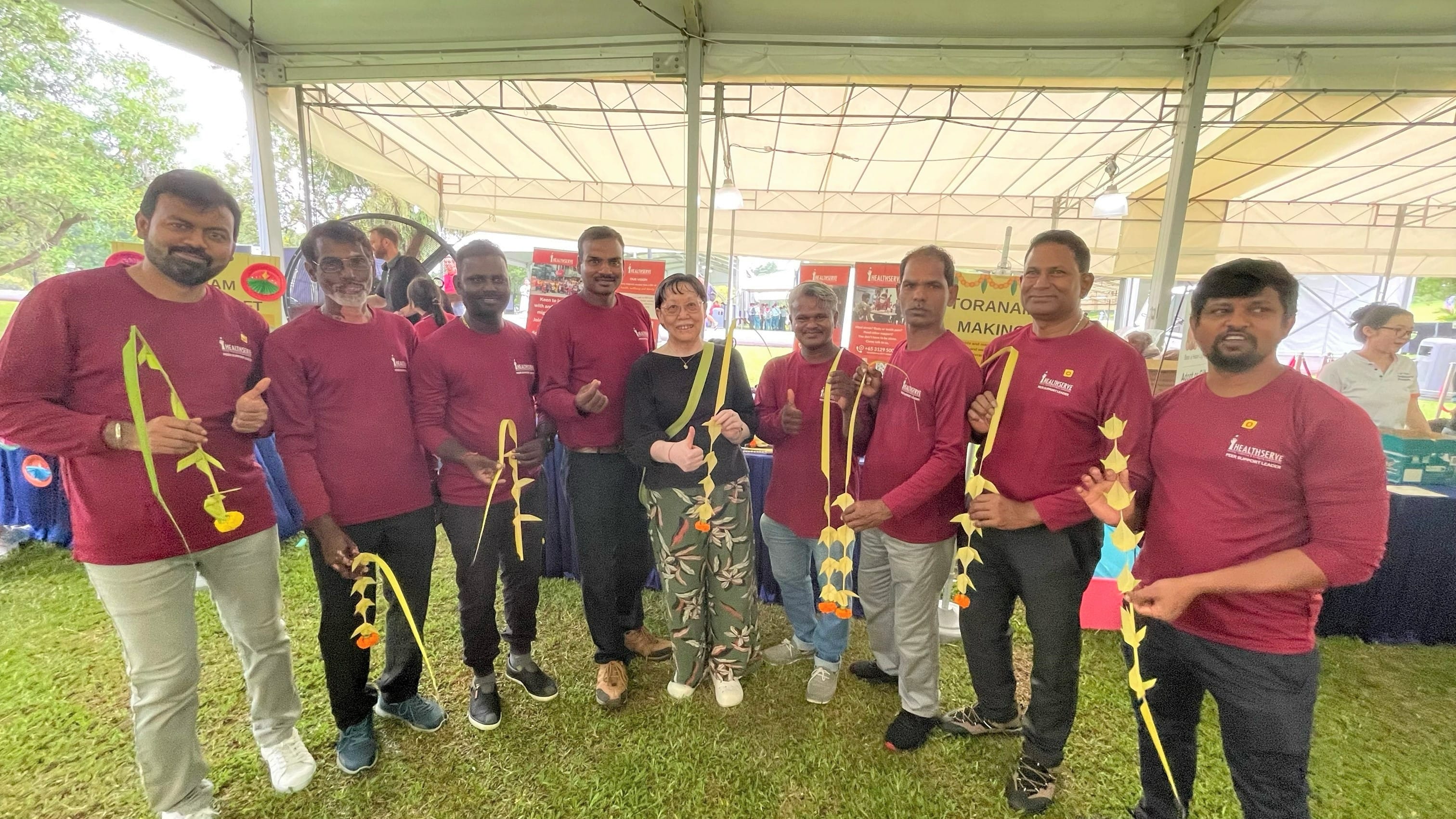 Group photo of visitors holding their hand weaved garland.