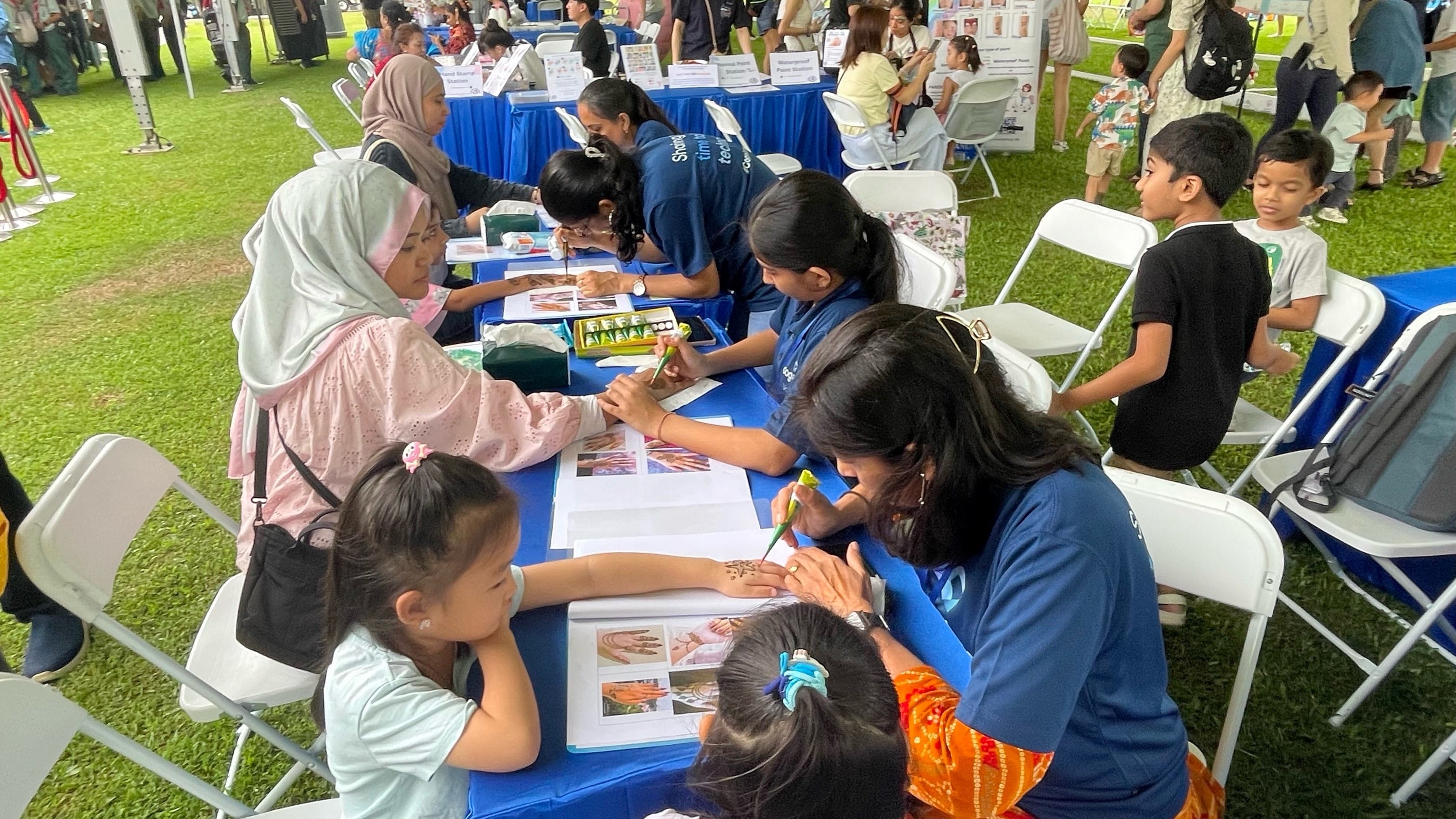 Visitors doing henna hand painting