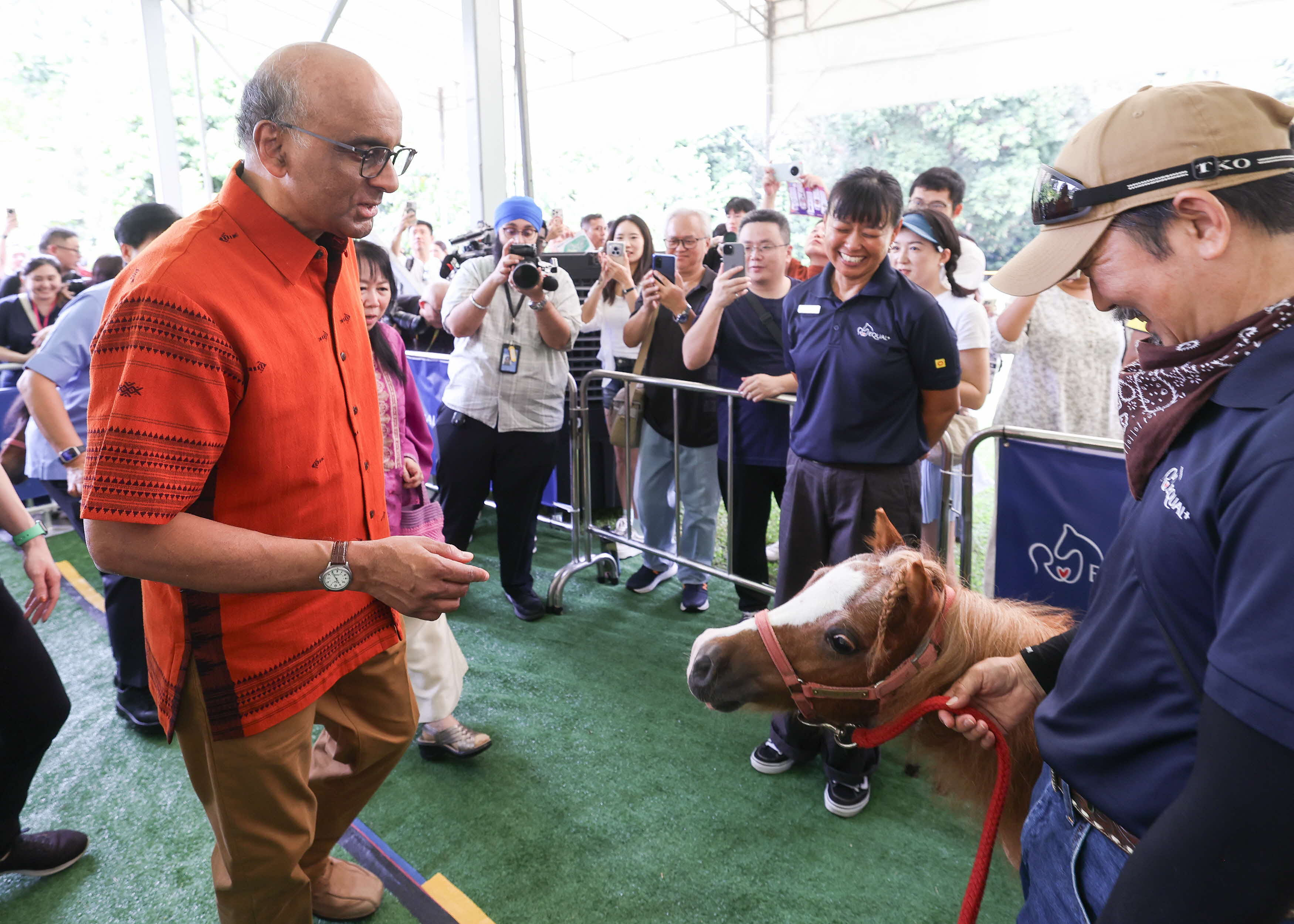 President Tharman speaking with person holding a pony