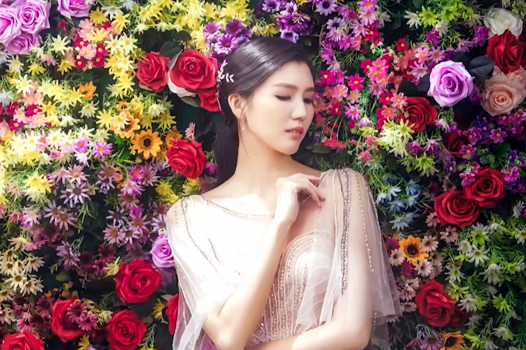 Jessica posing in front of a vibrant roses backdrop, before she had stroke.