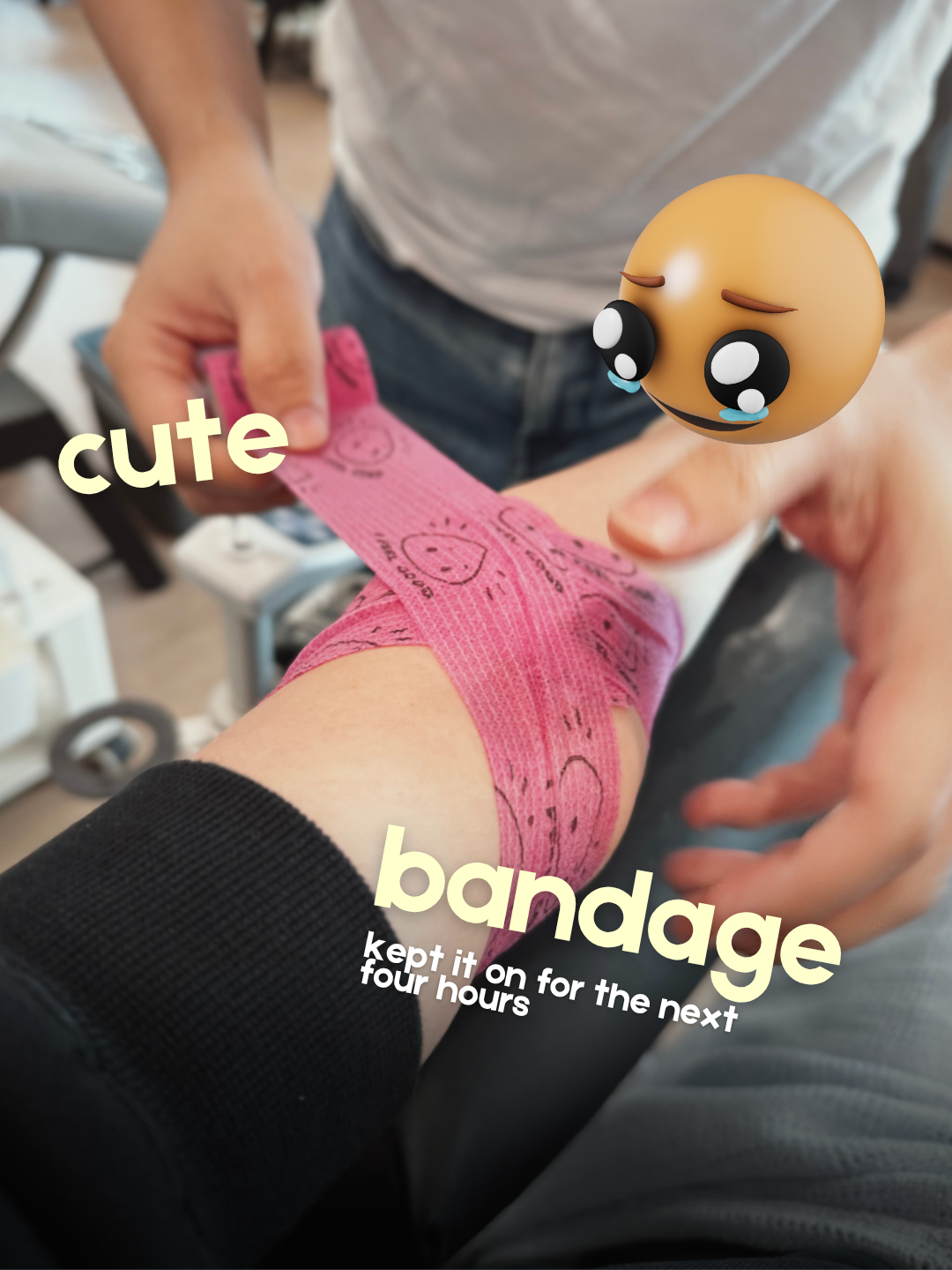 Close-up of a person's arm being wrapped in a pink compression bandage covered in small smiley face doodles. The text overlay reads, "cute bandage, kept it on for the next four hours."