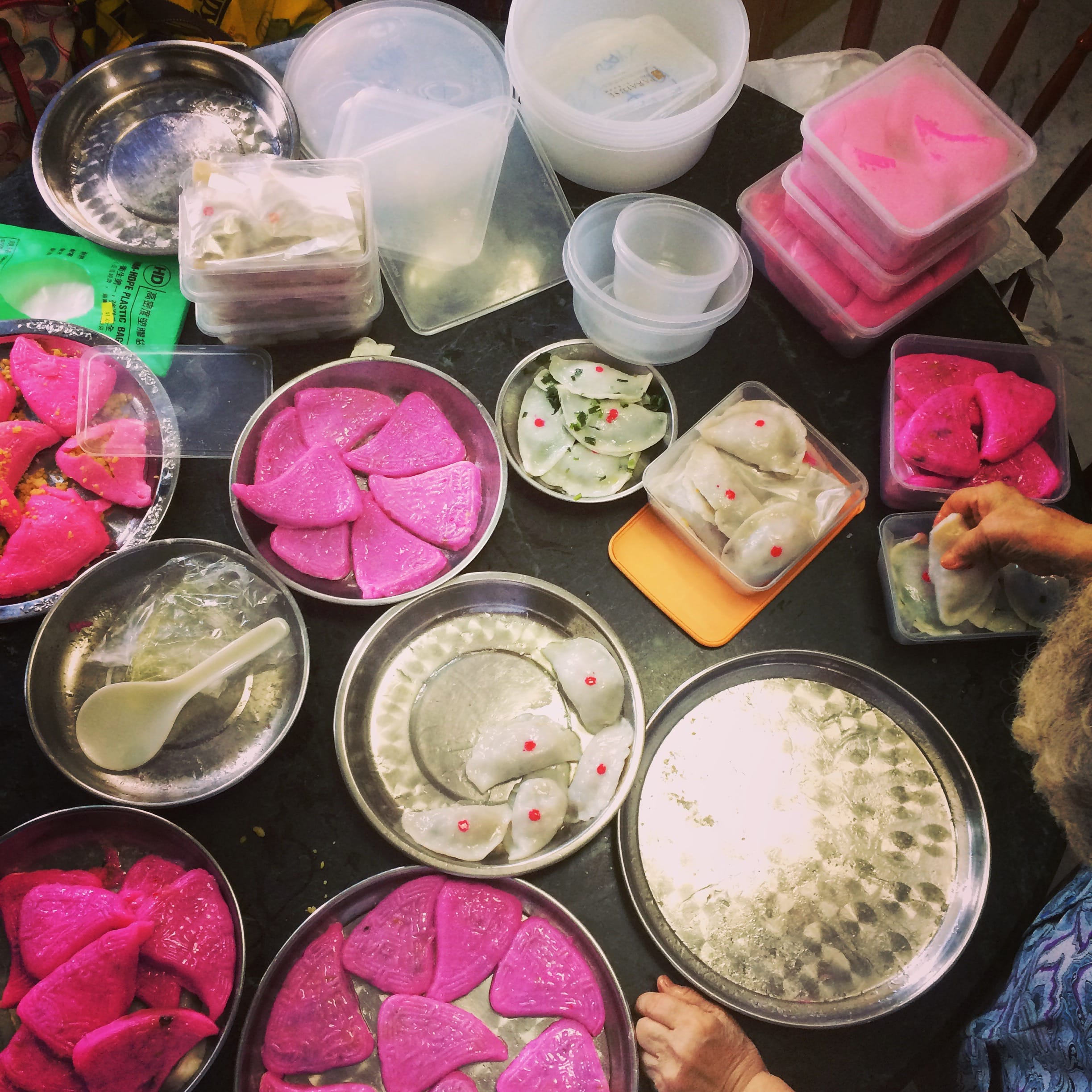 Family making various kueh on a marble table for chinese new year