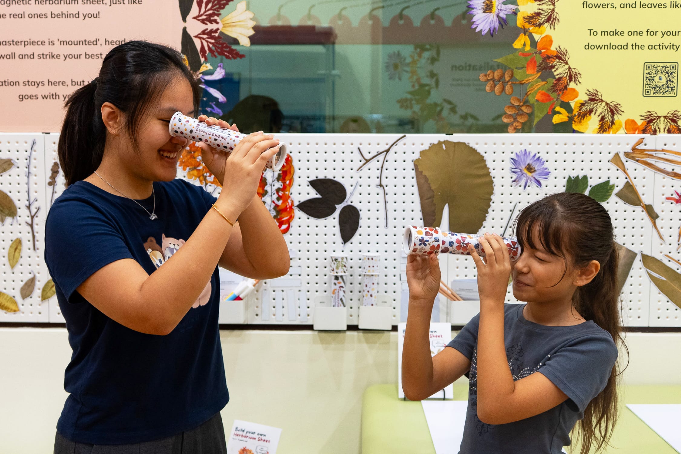 Children playing with plant-inspired kaleidoscopes at the exhibition