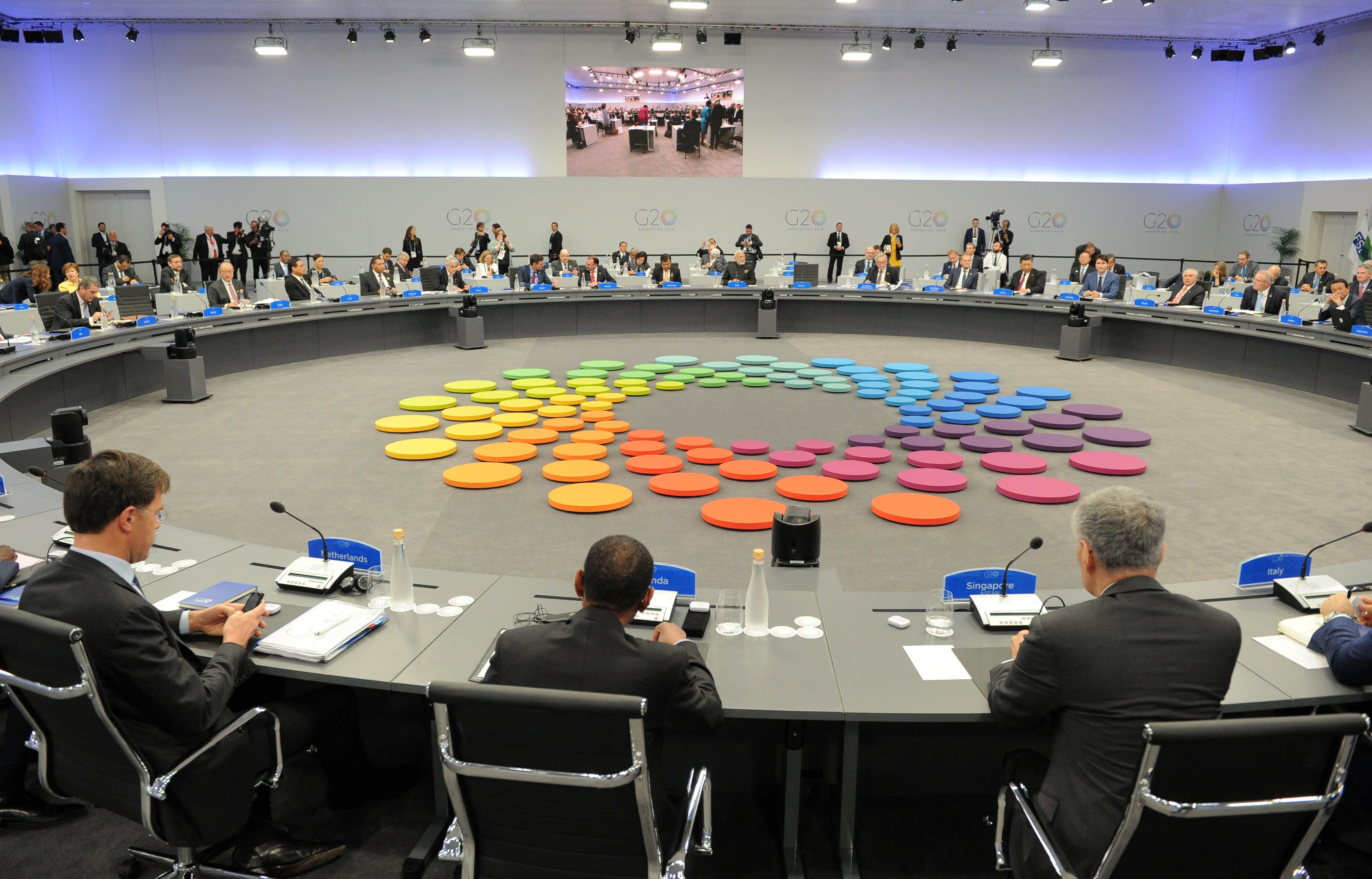 G20 meeting with delegates around a round table, colorful circles in the center.