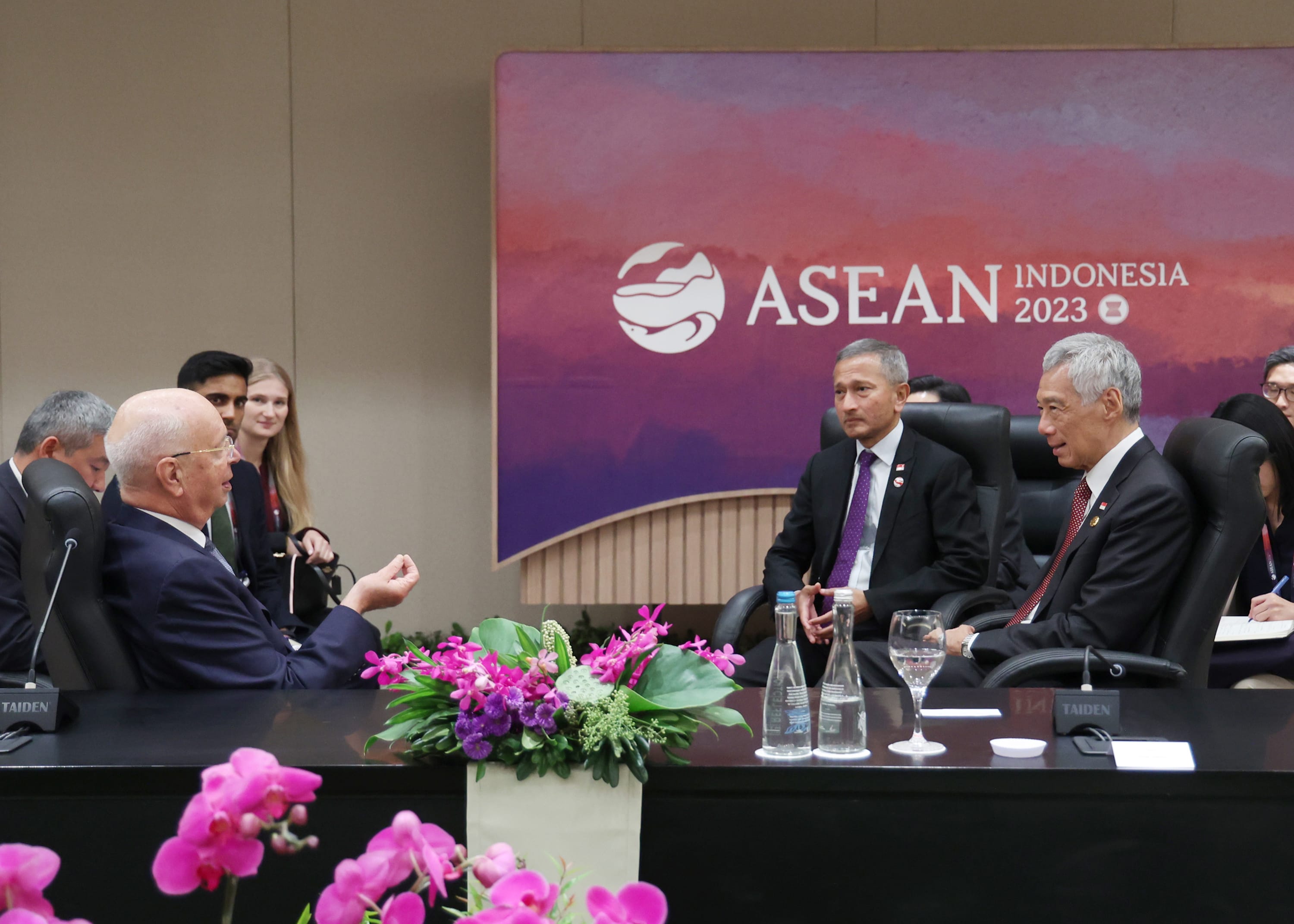 ASEAN Indonesia 2023 conference with speakers at a table; flowers and Taiden microphones.