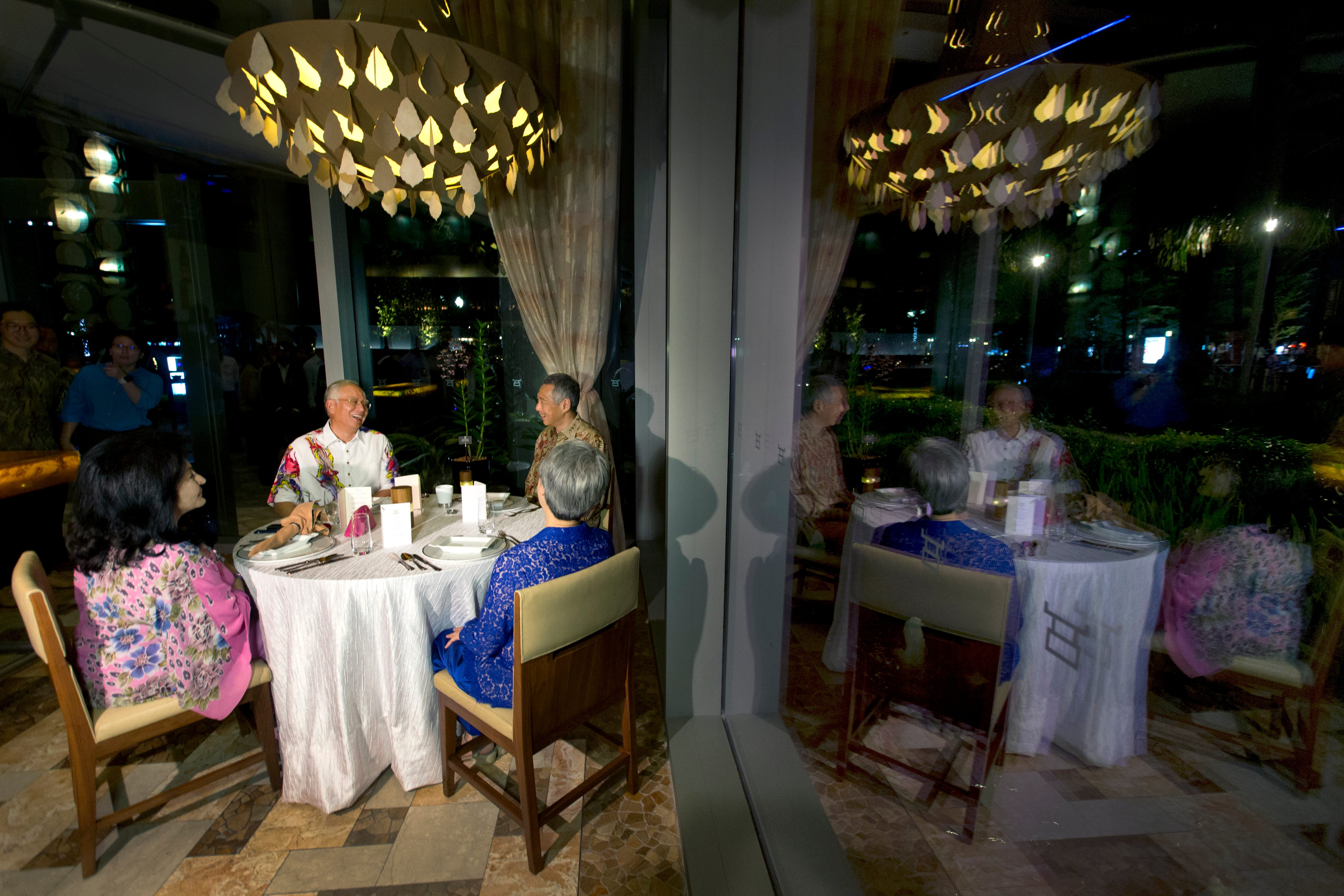 People seated at tables in a restaurant setting at night, interior view.