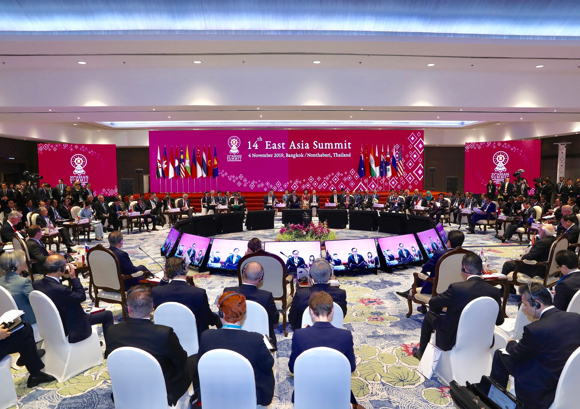 Large conference room at the 14th East Asia Summit, many people in formal attire seated around a circular table.