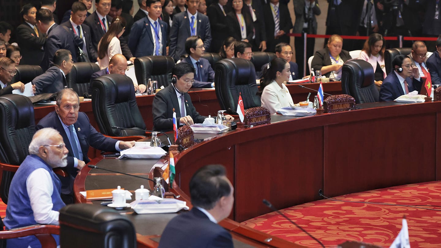 Heads of state in a meeting room with Modi, Lavrov, and country nameplates on a table.