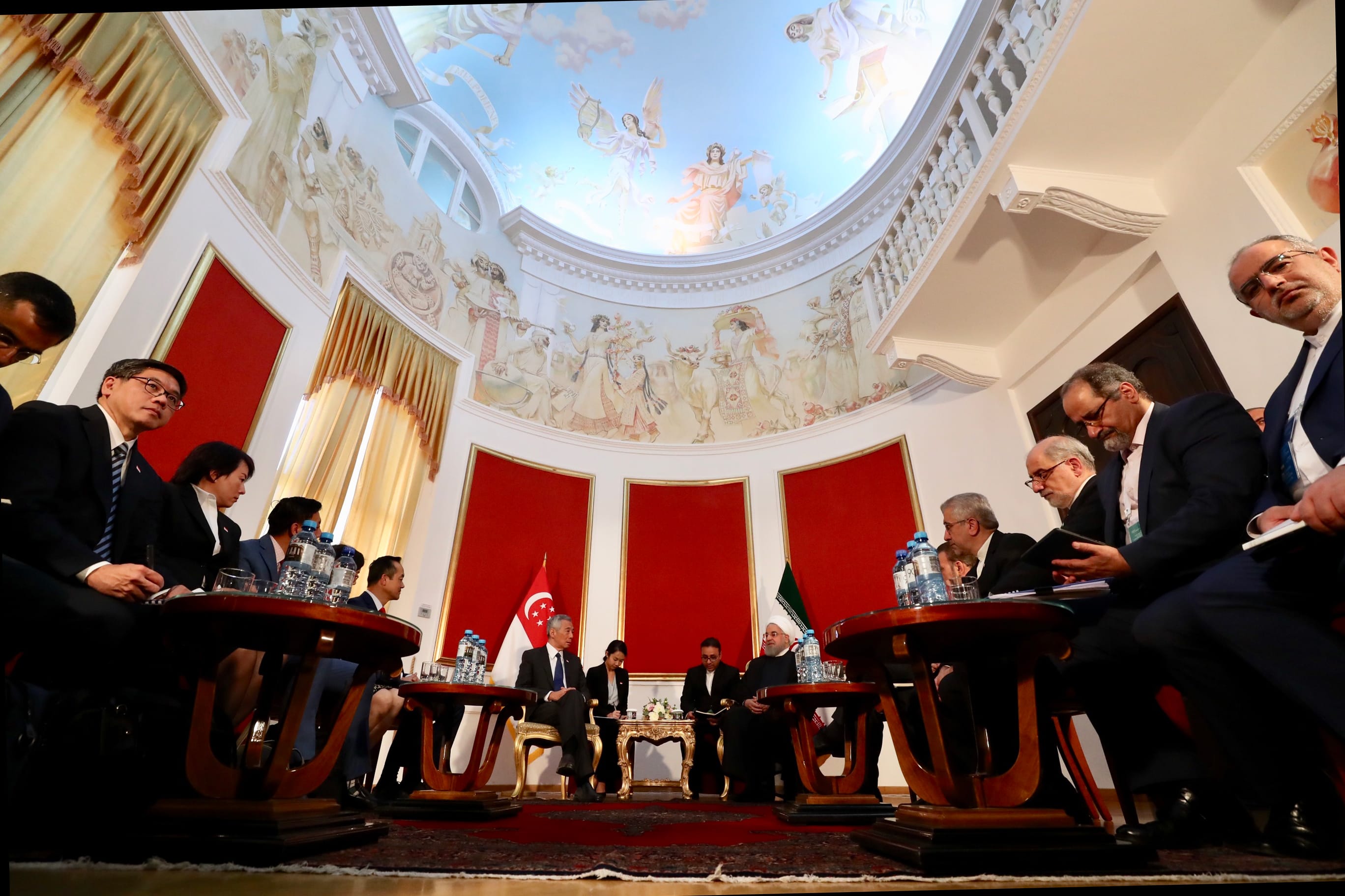 Meeting in ornate room with painted ceiling, Singaporean & Iranian flags, and President Rouhani.