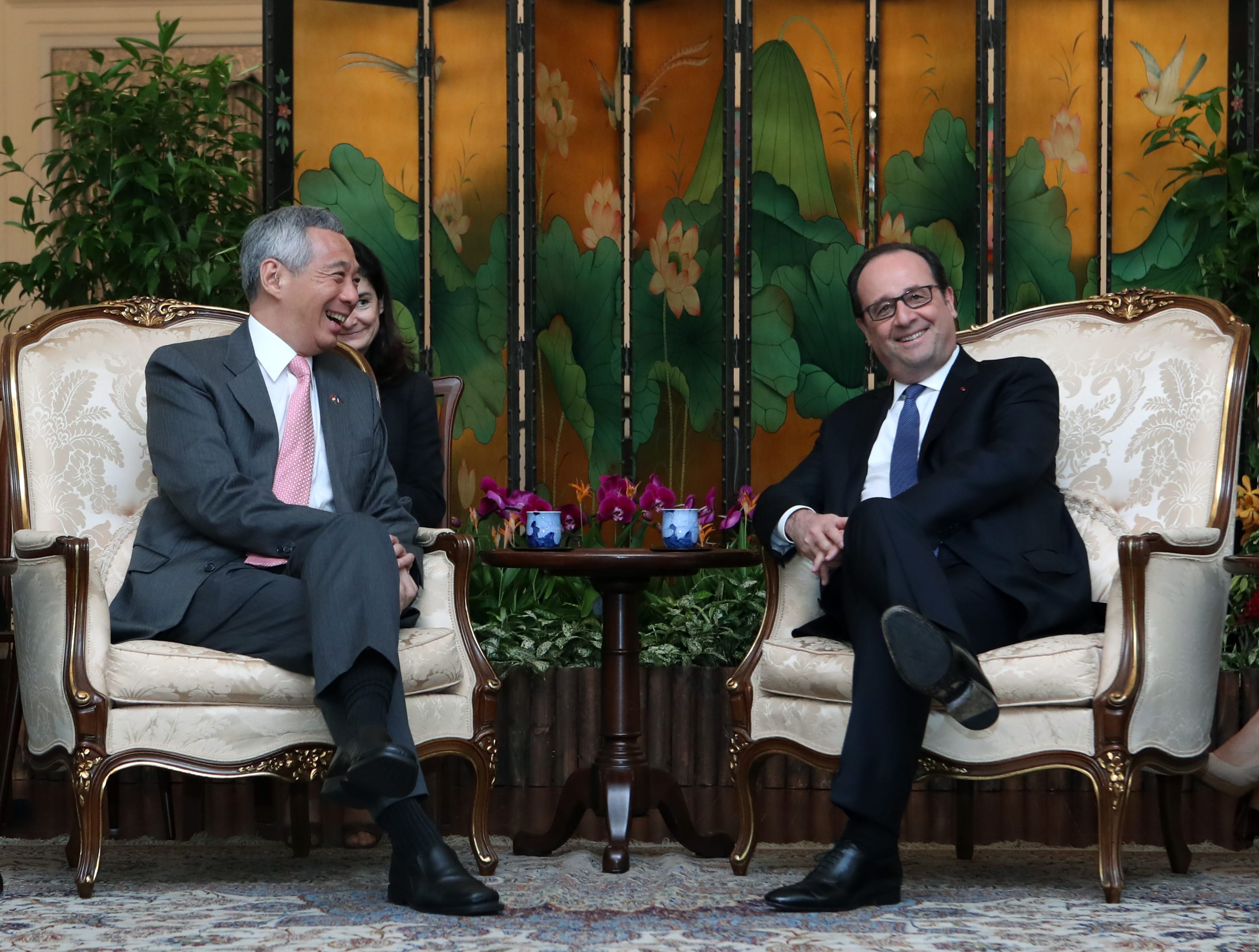 Lee Hsien Loong and François Hollande sit in ornate chairs before a decorative screen.