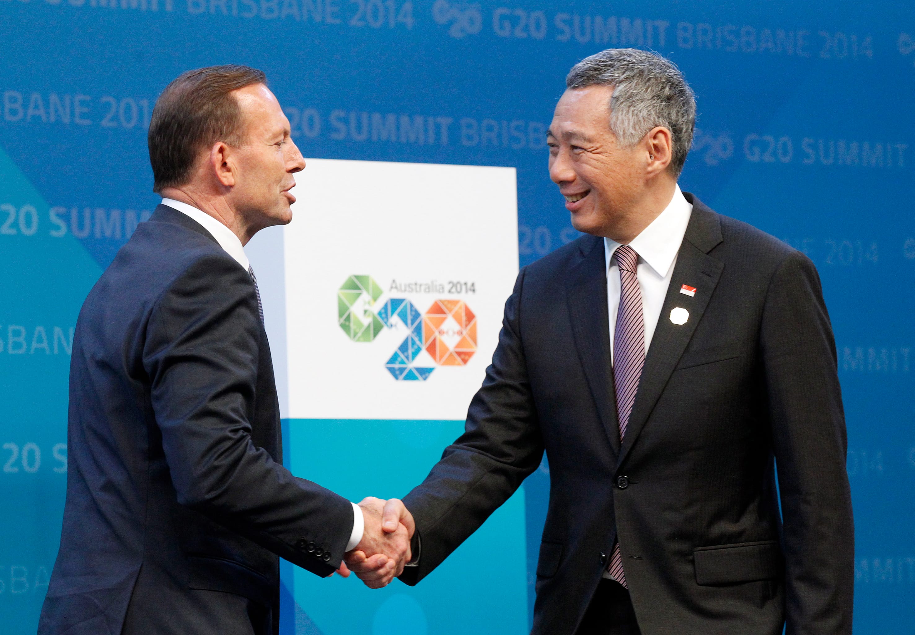 Tony Abbott and Lee Hsien Loong shaking hands in front of G20 Summit Brisbane 2014 backdrop.