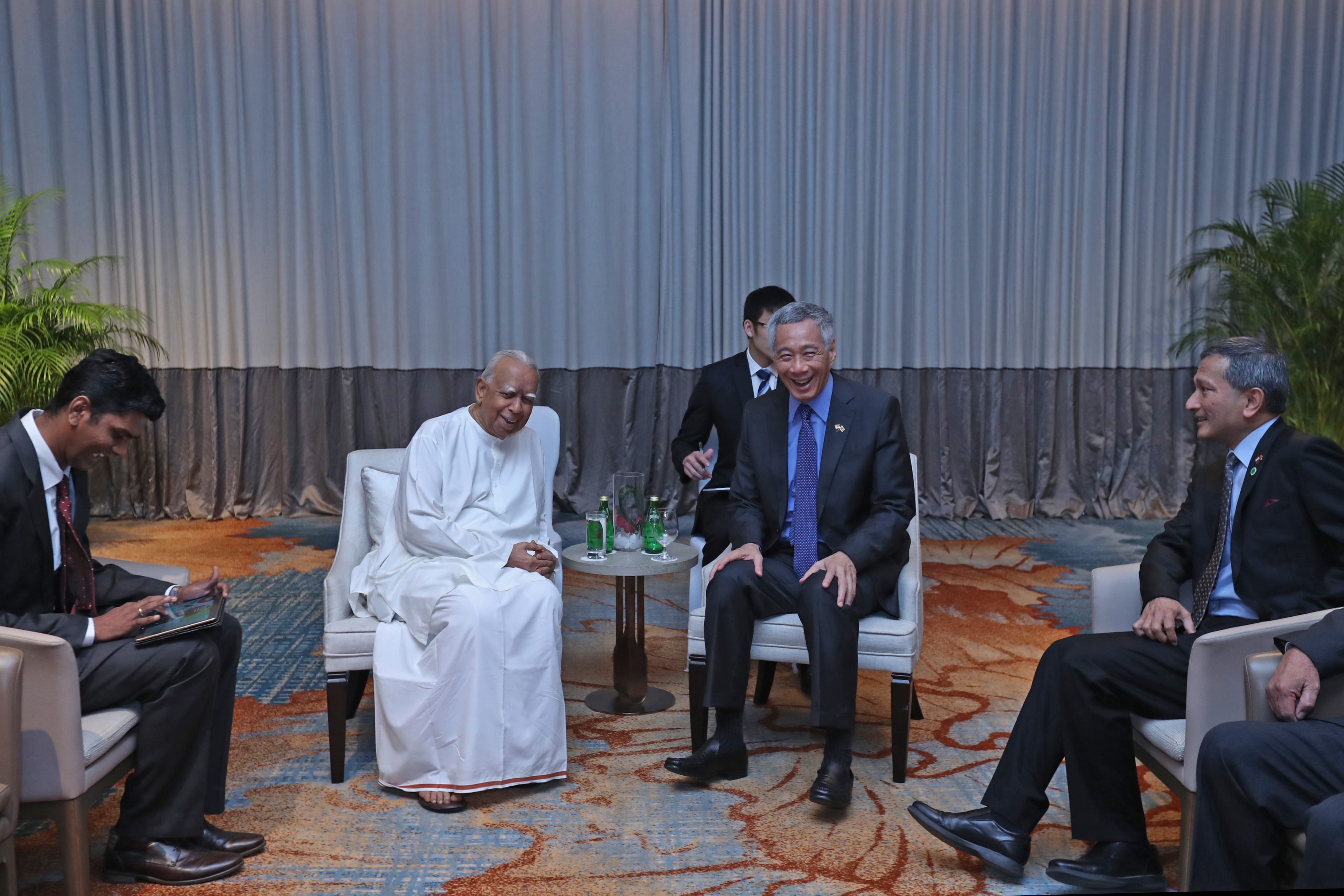 Singapore's Prime Minister Lee Hsien Loong with others seated in an office space.