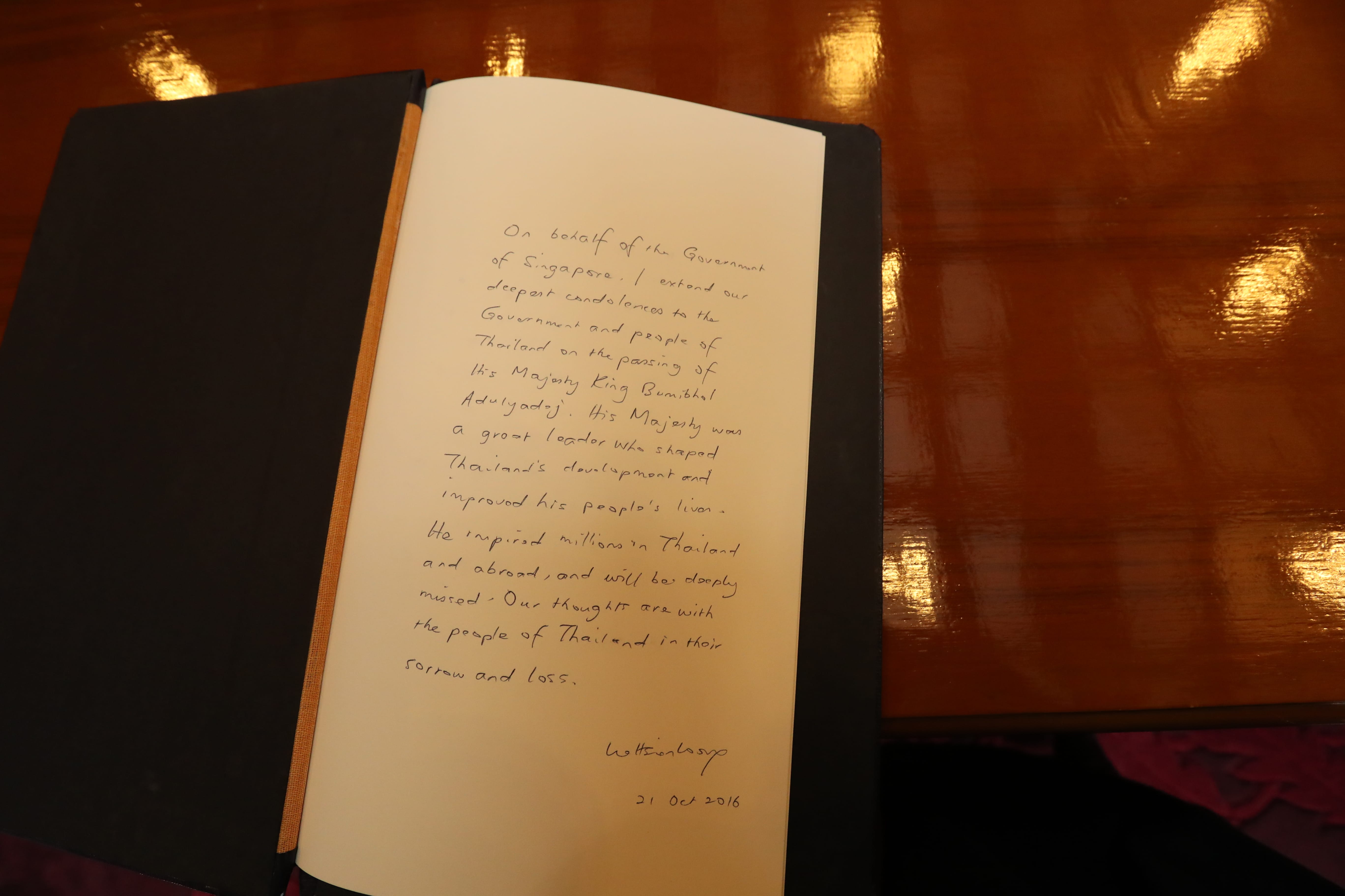 Open condolence book with handwritten message on behalf of the Government of Singapore.