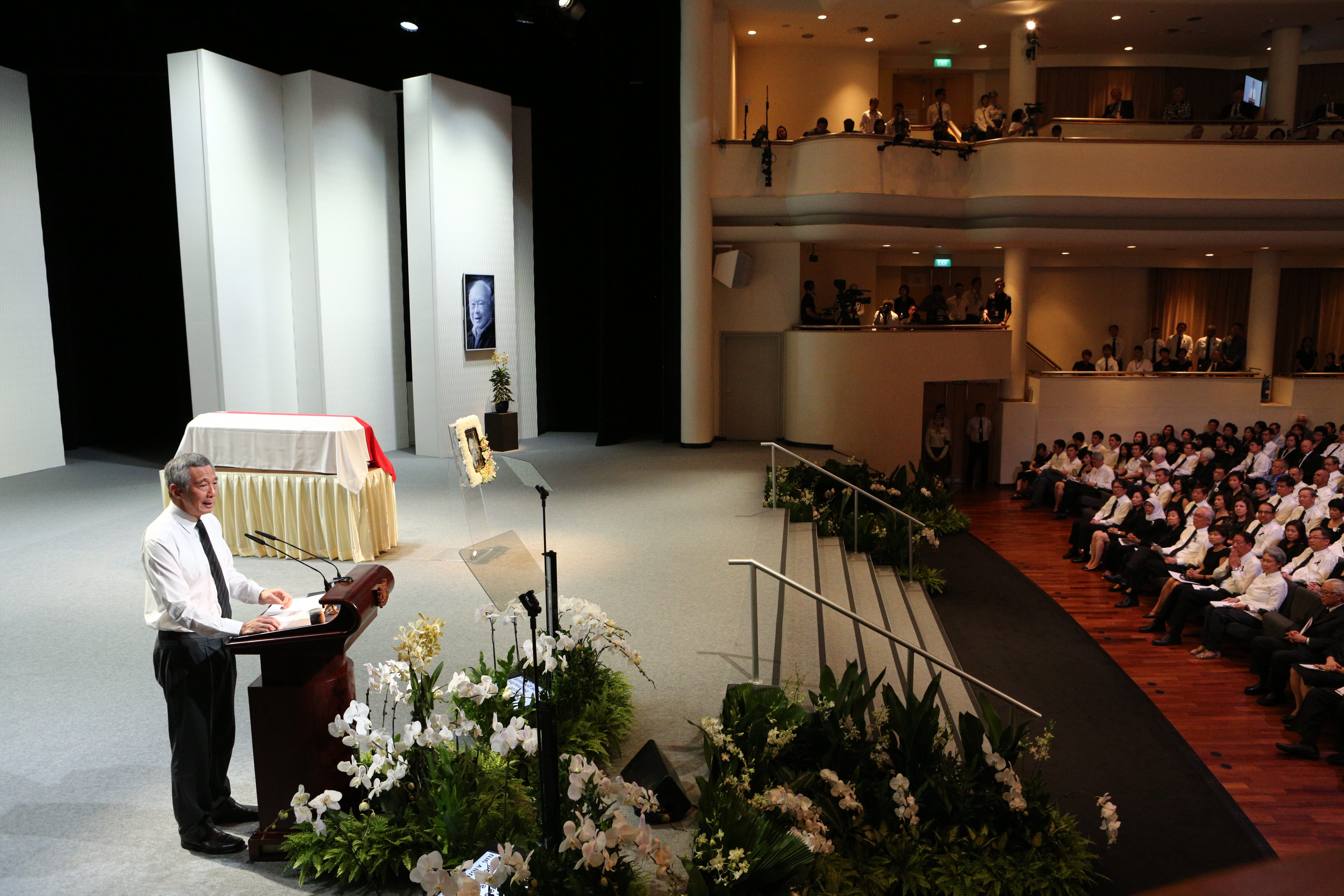 Lee Hsien Loong at Lee Kuan Yew memorial. Casket, portrait, and crowd visible.
