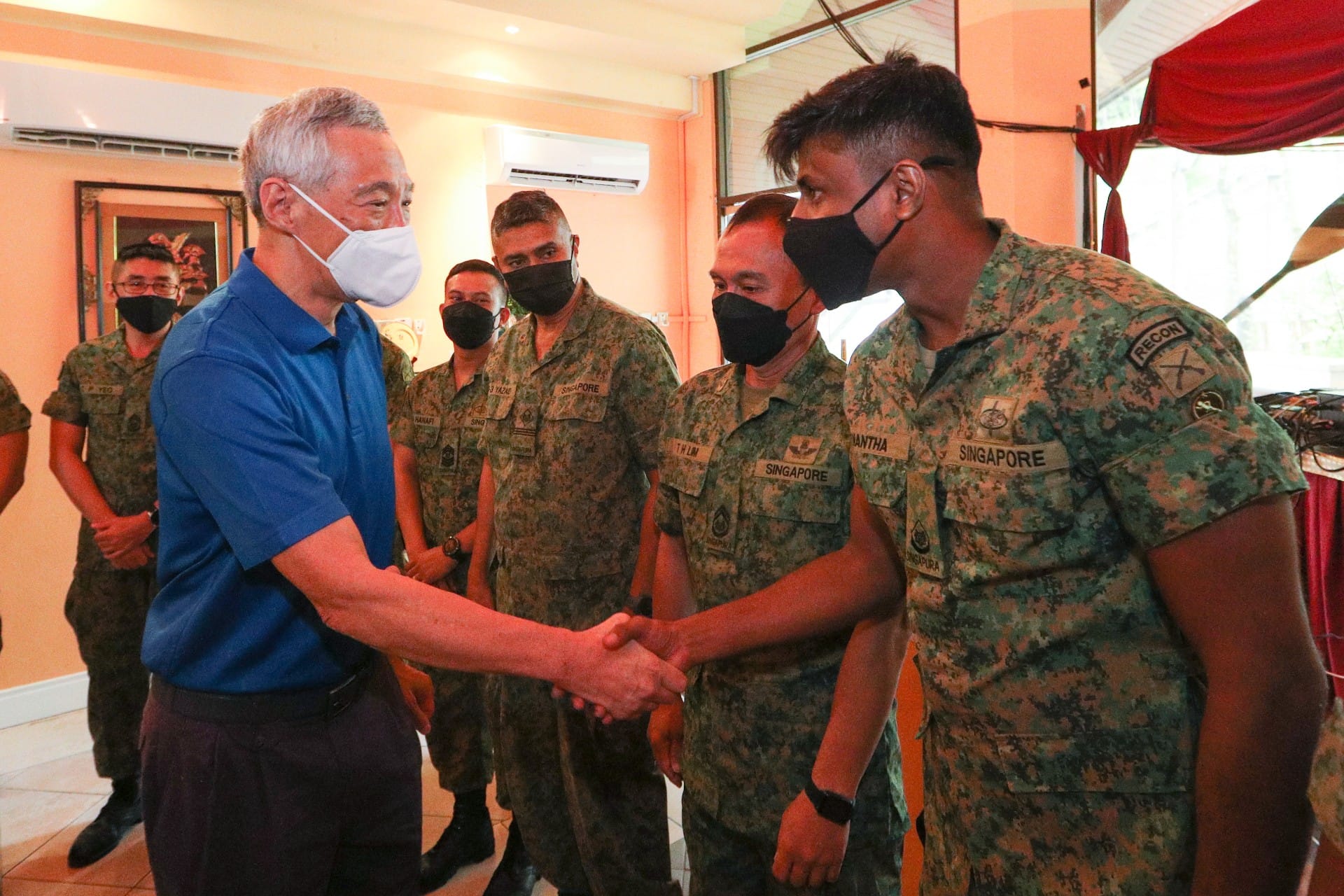 Lee Hsien Loong shakes hands with uniformed Singapore RECON soldiers, all wearing face masks.