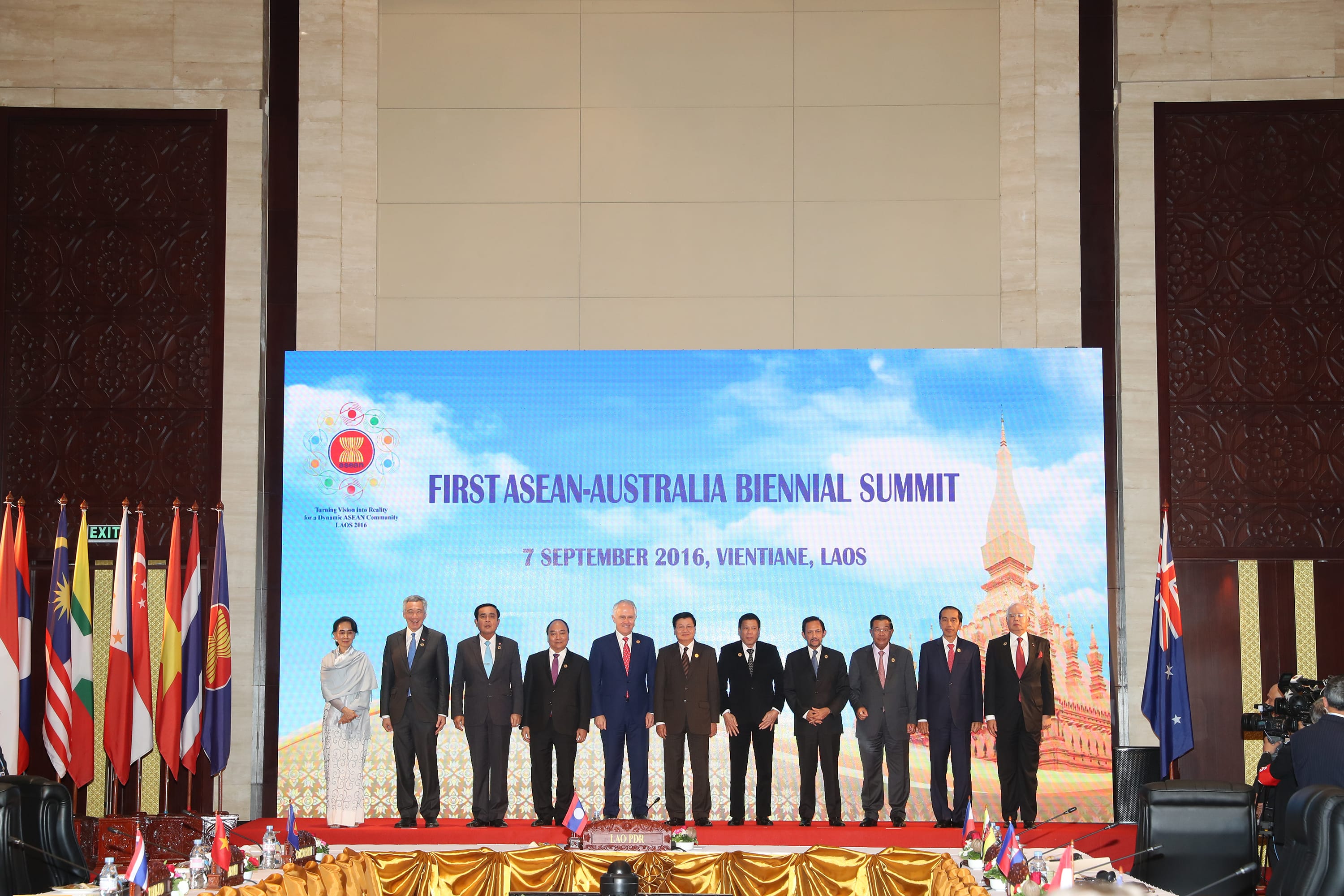 Leaders at First ASEAN-Australia Biennial Summit, Vientiane, Laos, with flags and a screen backdrop.