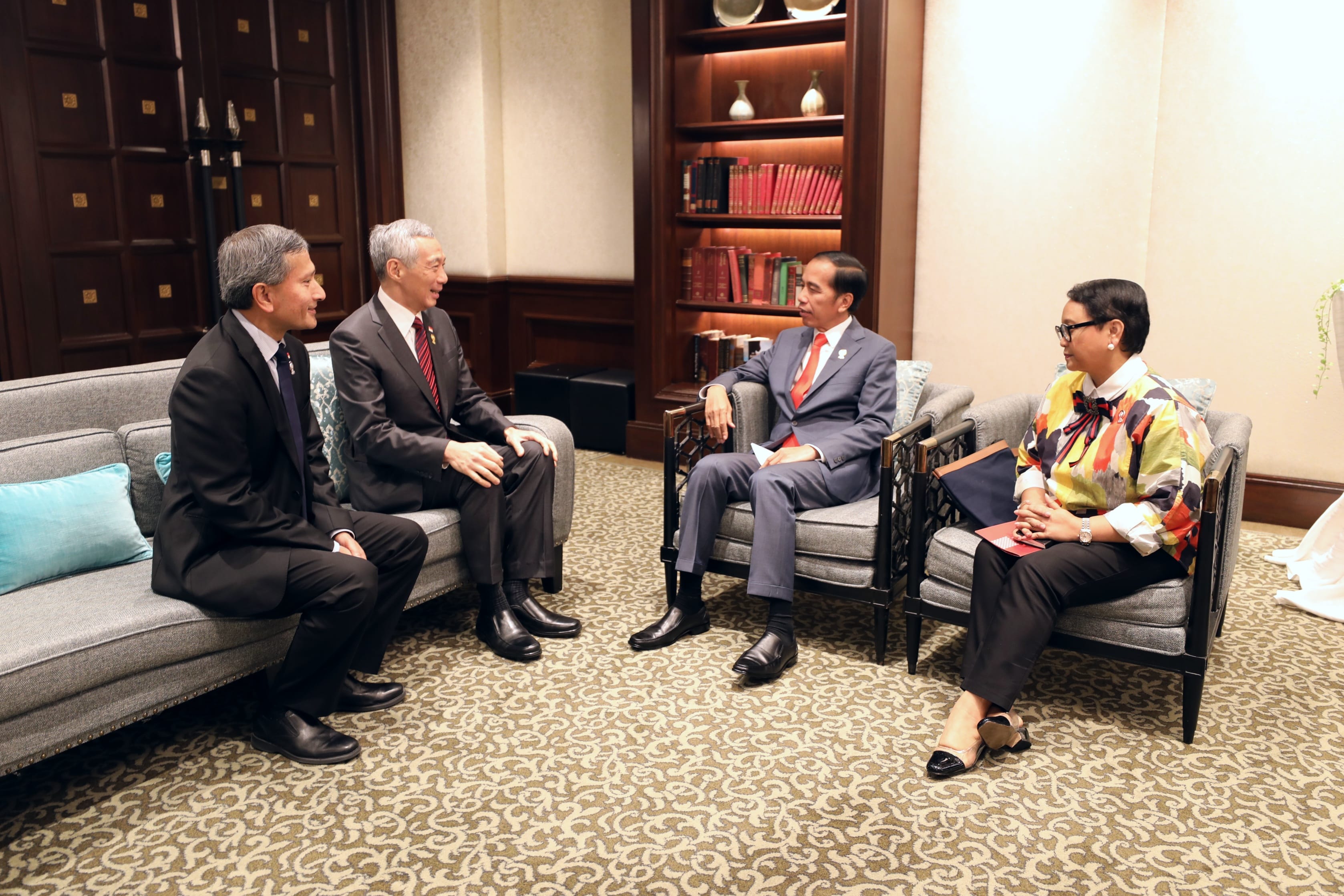 Four people including Indonesian President Widodo seated indoors, converse.