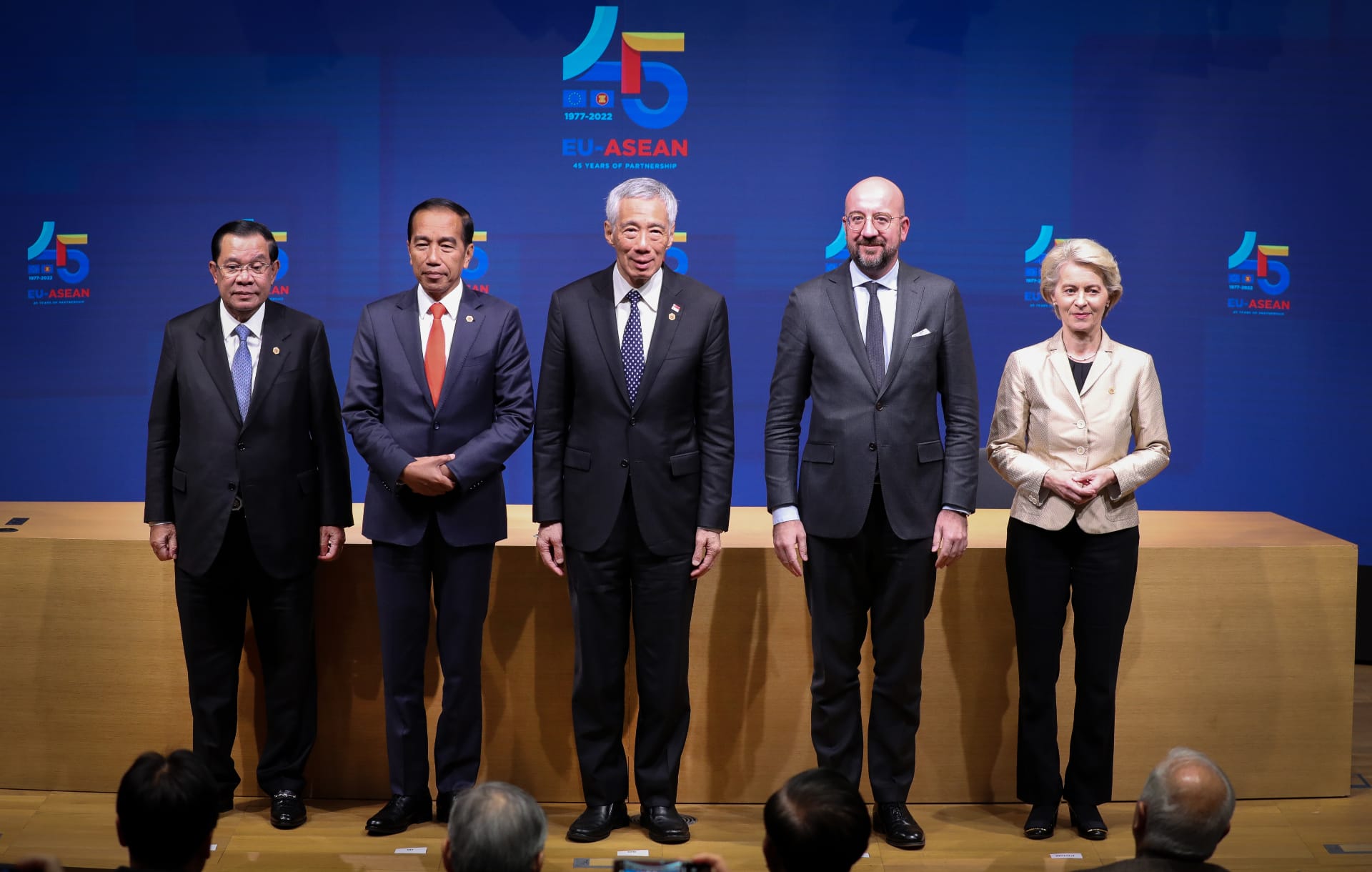 Five people in suits stand before a blue EU-ASEAN backdrop.