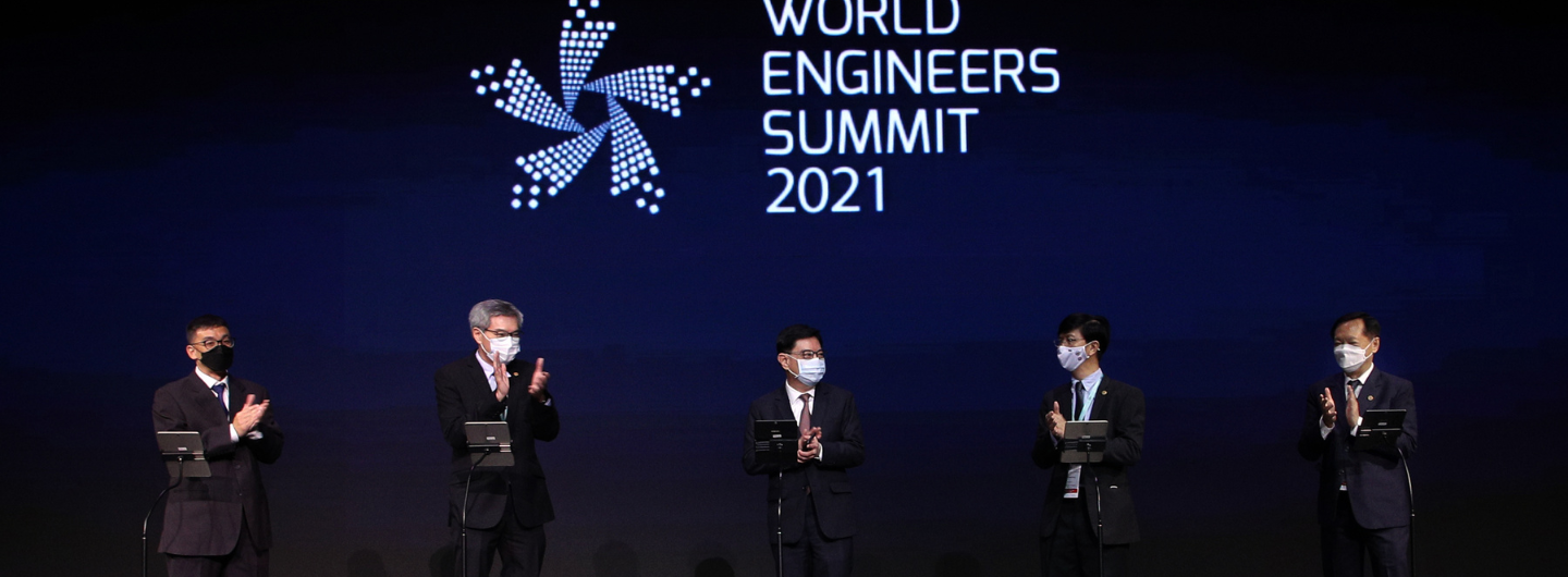 Five masked people in suits clapping under "World Engineers Summit 2021" logo.