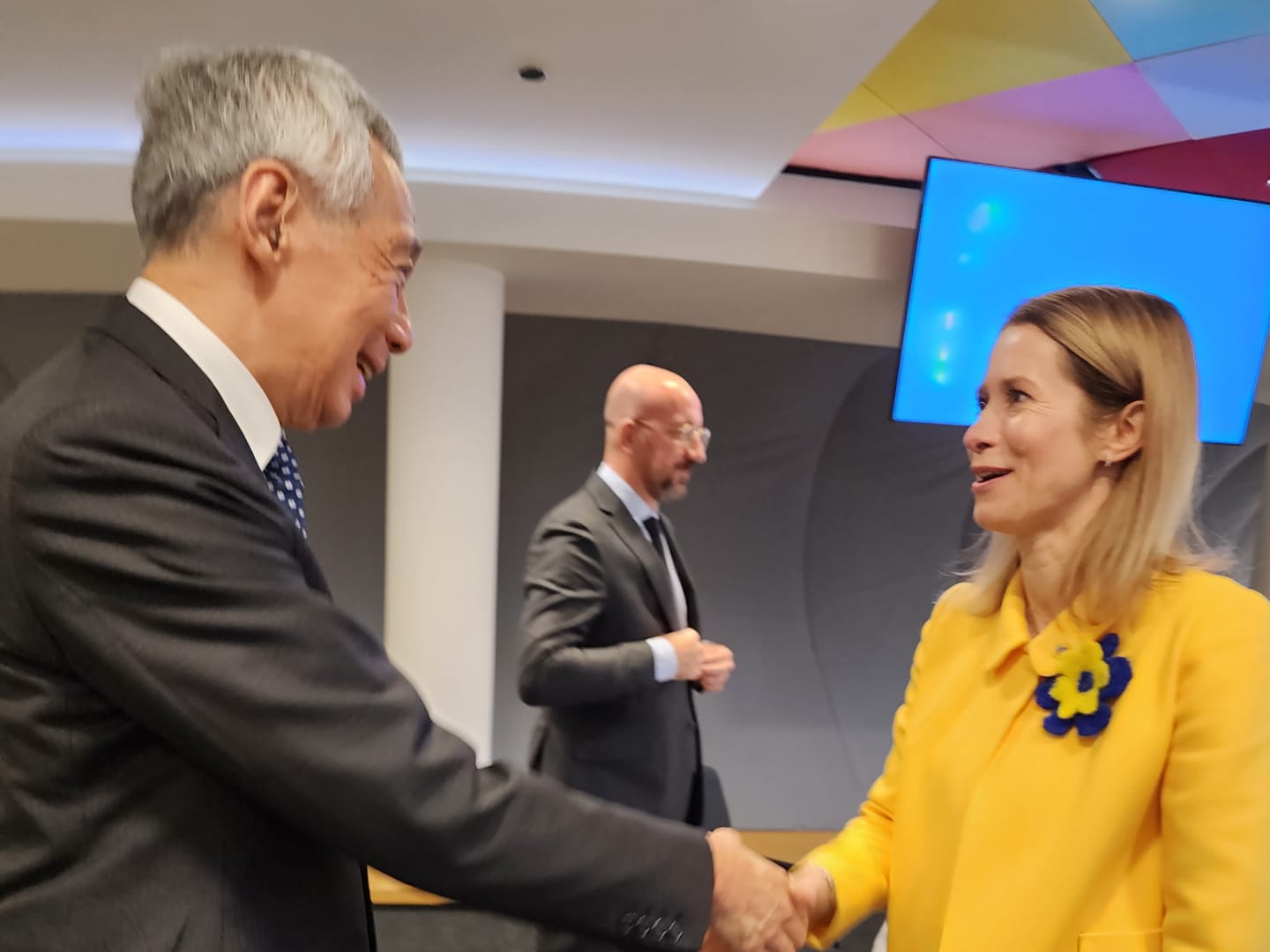 Lee Hsien Loong and Kaja Kallas shaking hands, third man in suit behind.
