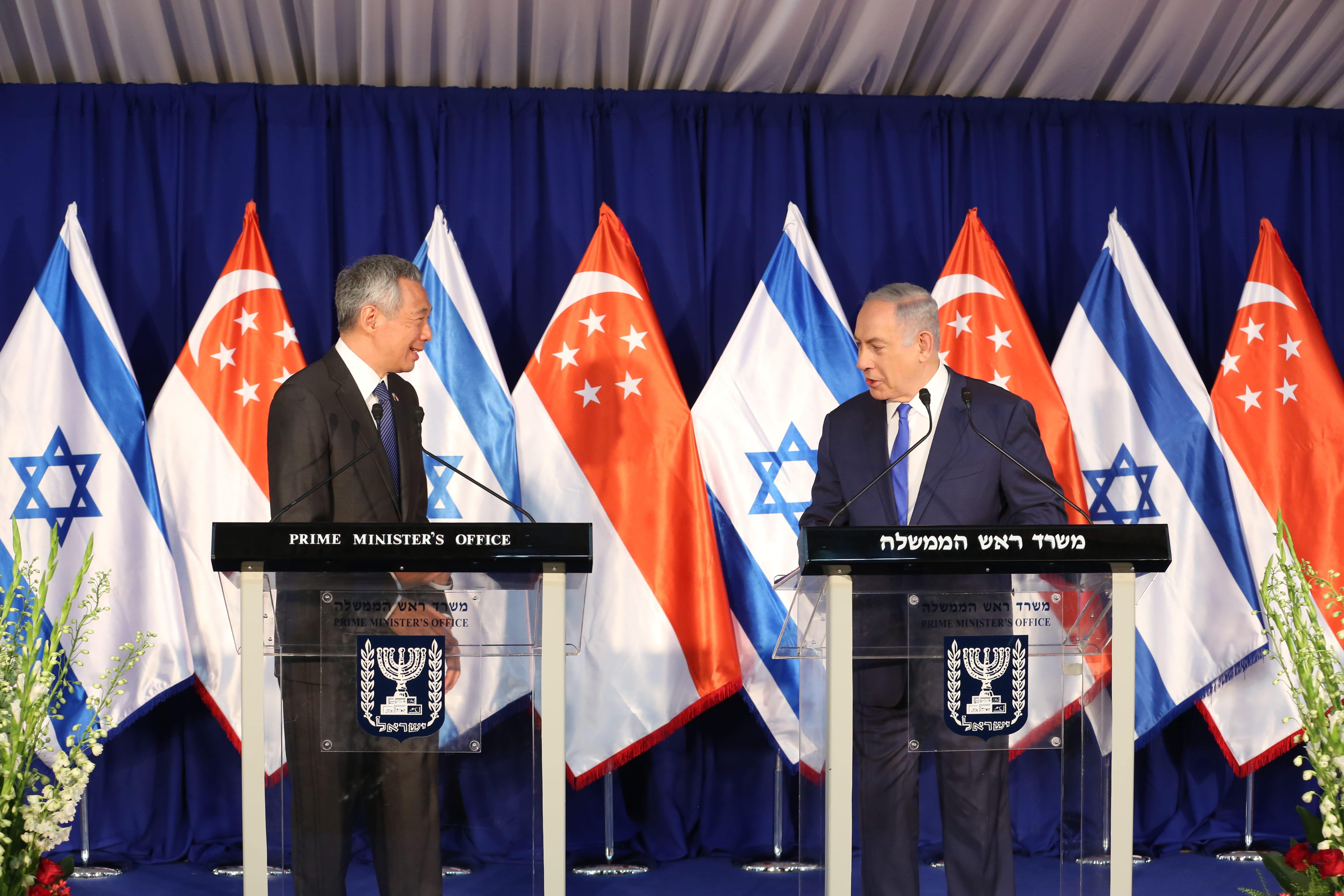 Lee Hsien Loong and Benjamin Netanyahu at lecterns with Singaporean and Israeli flags.