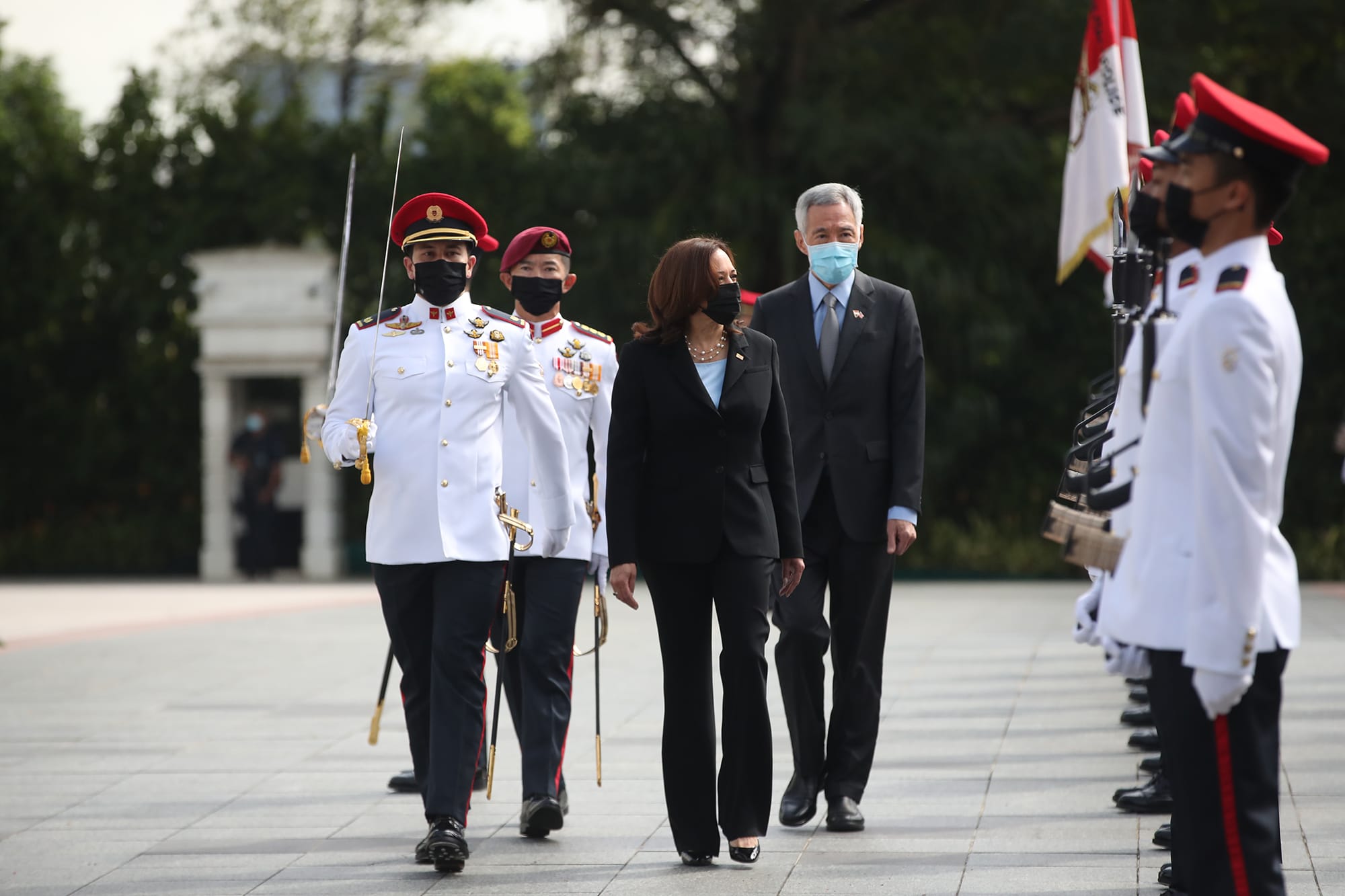 Kamala Harris with Lee Hsien Loong walk with masked military honor guard.