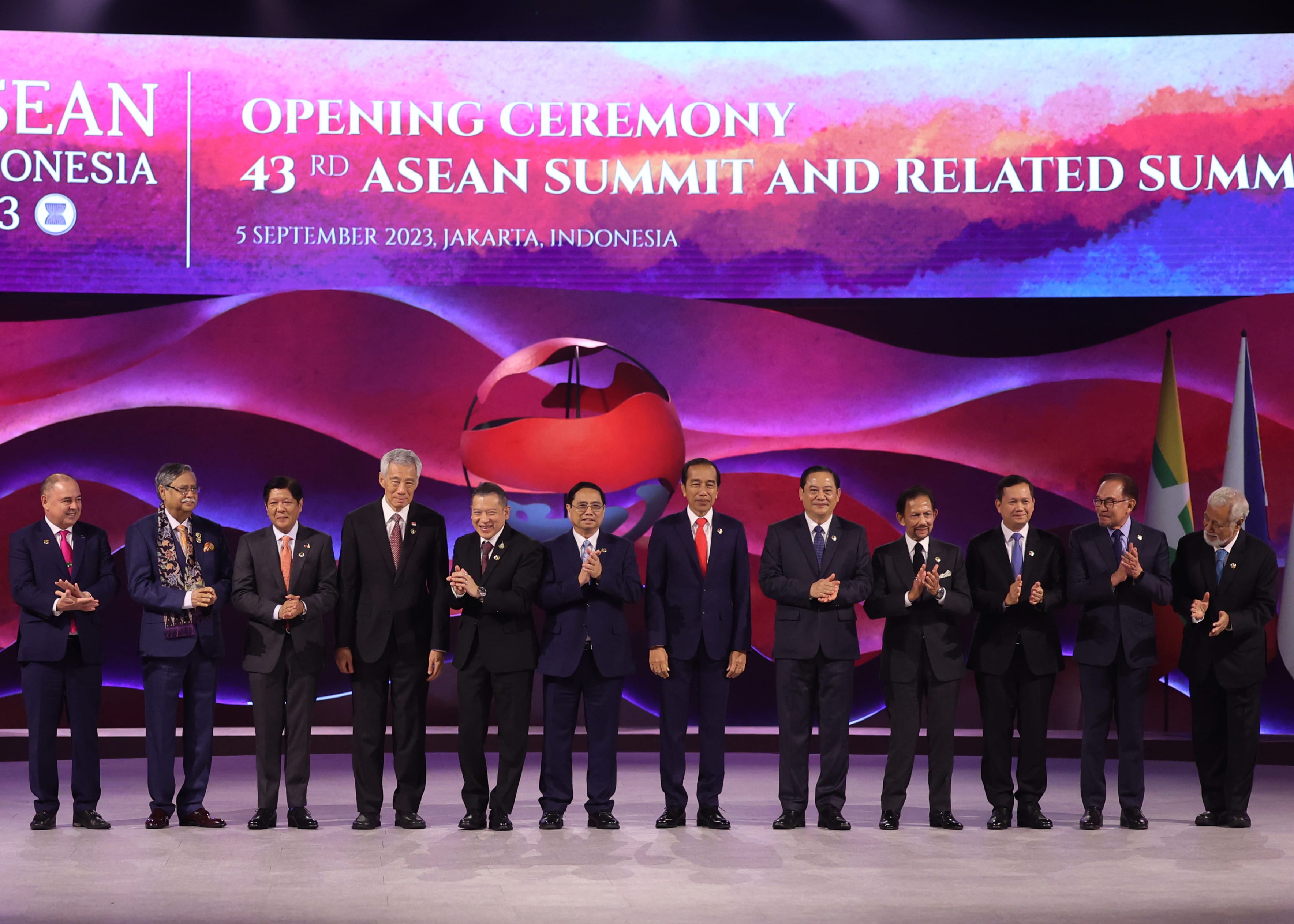 Group of dignitaries in suits applaud at the 43rd ASEAN Summit opening ceremony.