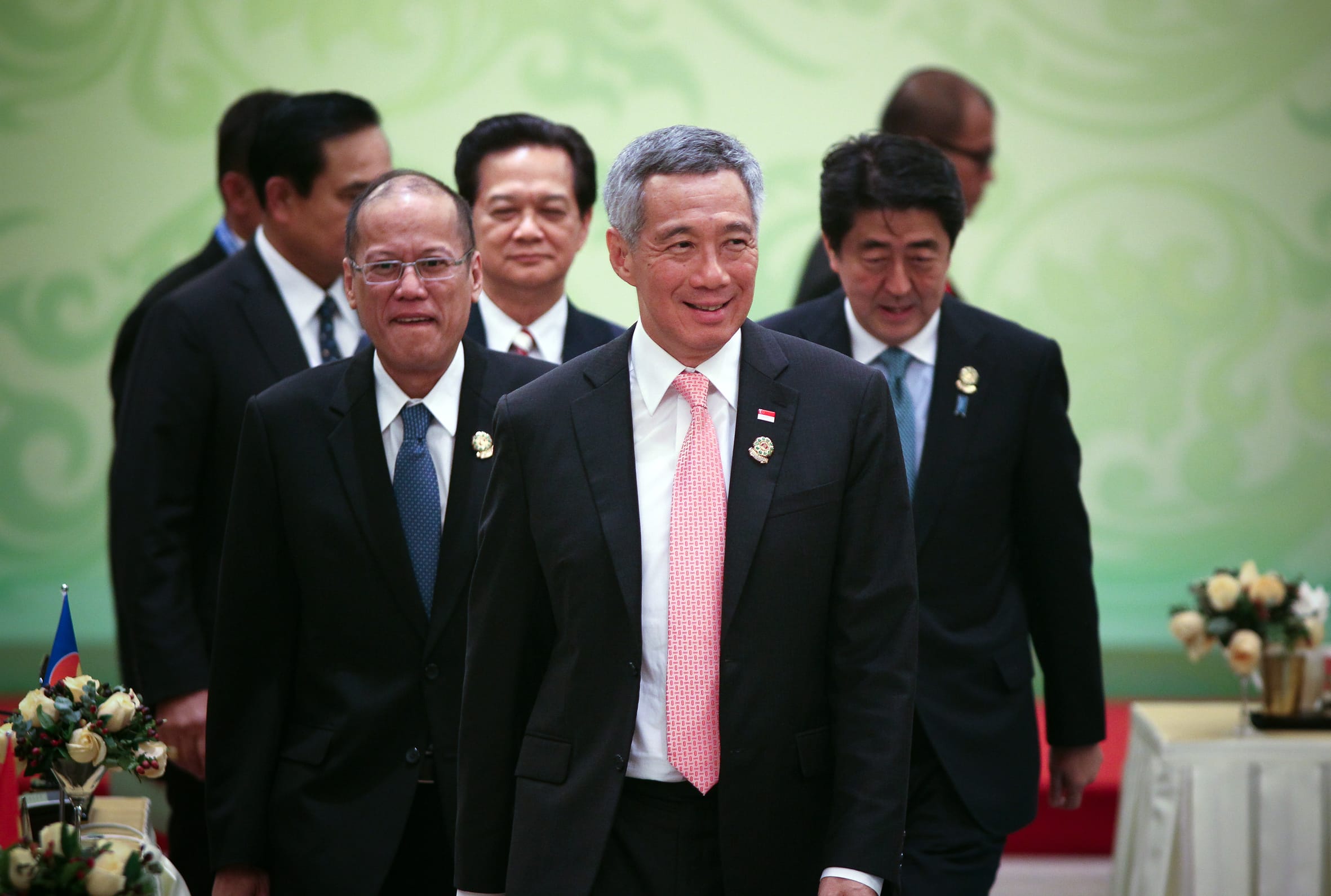 Group of men in suits, including Lee Hsien Loong and Shinzo Abe, walking in a line.