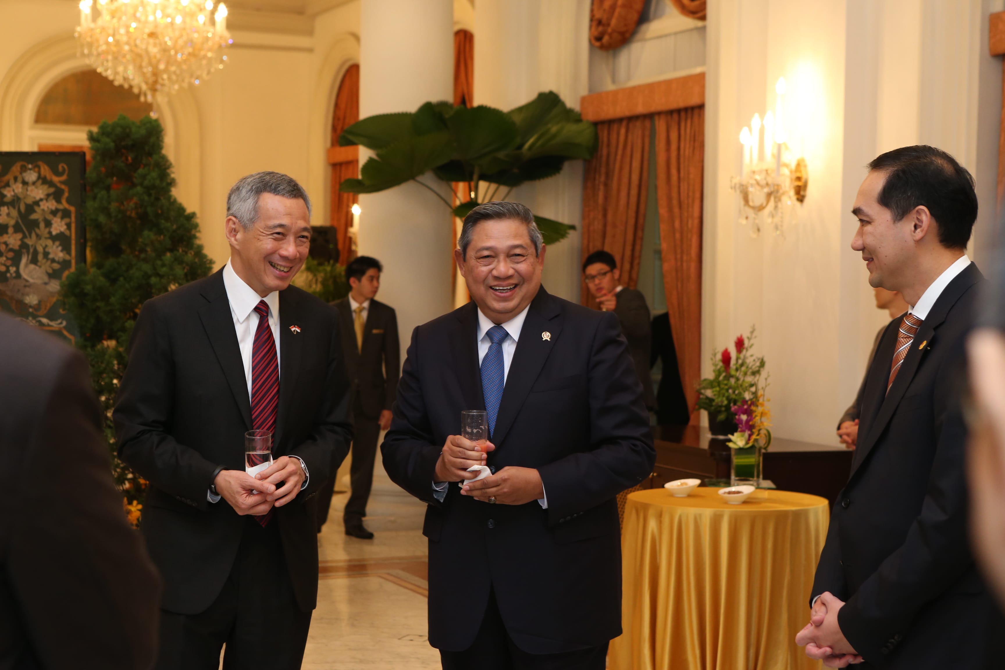 Lee Hsien Loong and Susilo Bambang Yudhoyono in suits holding drinks, smiling, at an indoor event.